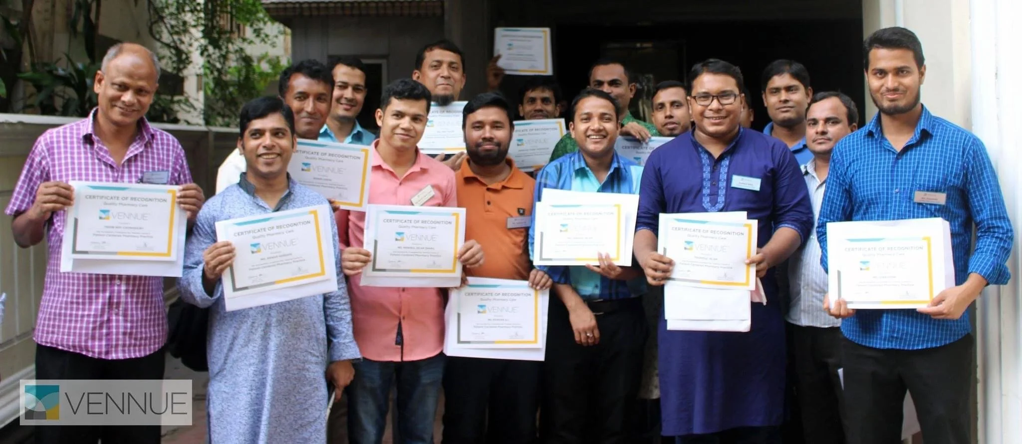 Group of men holding Vennue certificates in an indoor setting, smiling for a photo.