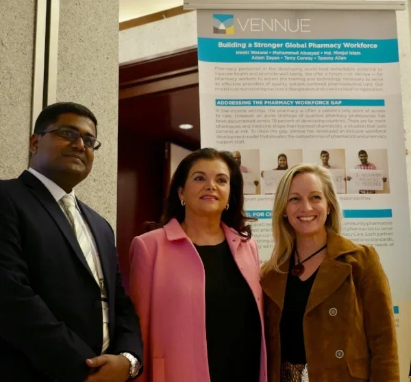 FIP’s Dr Carmen Pena meets with Vennue leadership standing in front of a banner with the title 'Building a Stronger Global Pharmacy Workforce' at FIPs Global Congress Conference.