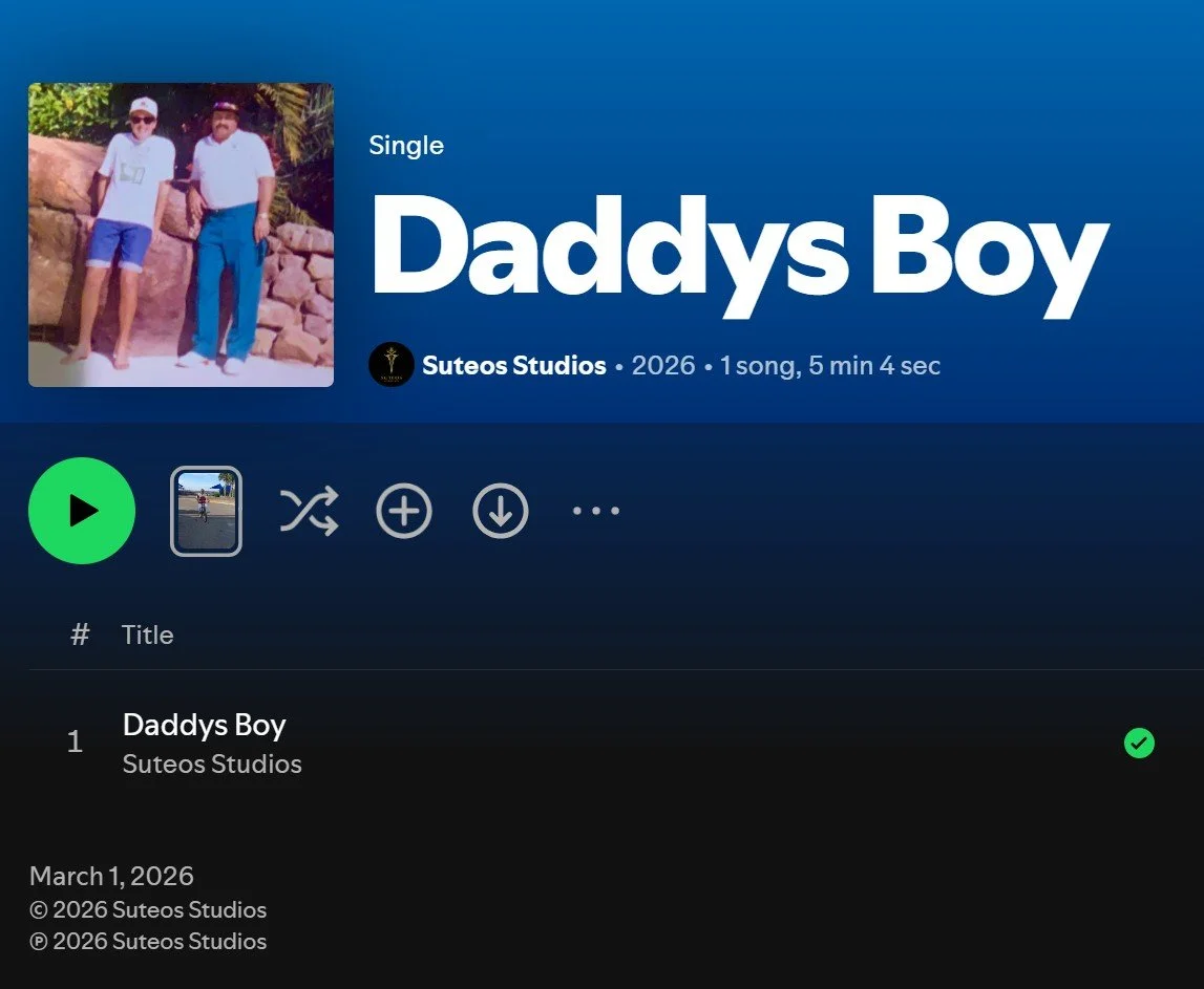 Screenshot of a music streaming app showing the song "Daddys Boy" by Suteos Studios, released in 2026, with a cover art photo of two men standing outdoors.