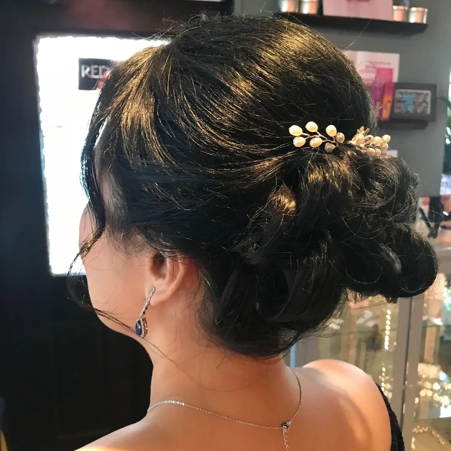 hair styled in an elegant updo, adorned with a pearl hair accessory by Salon 230 Daytona Beach