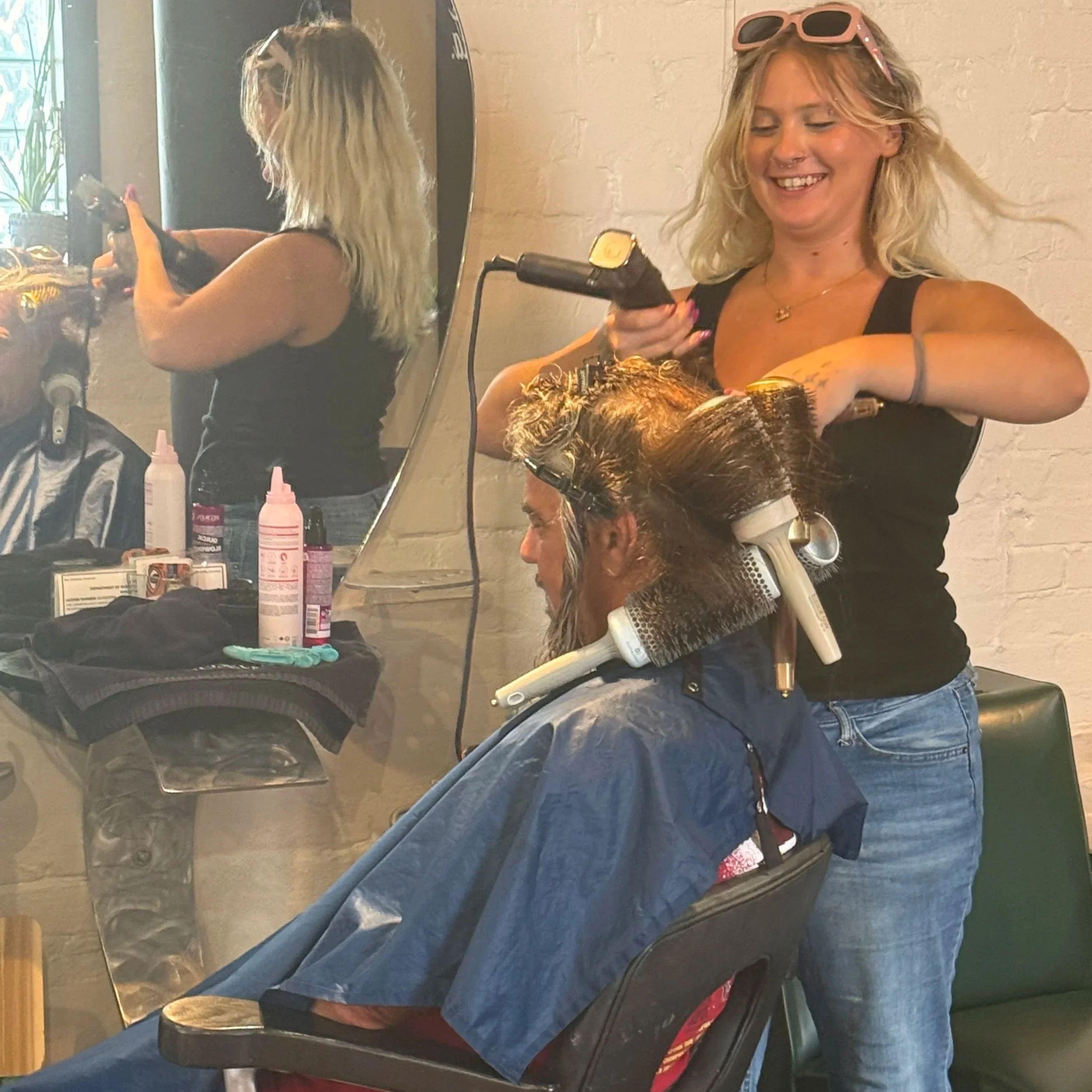 A hairstylist blow-drying a blow dry style blowout by Salon 230 Daytona Beach