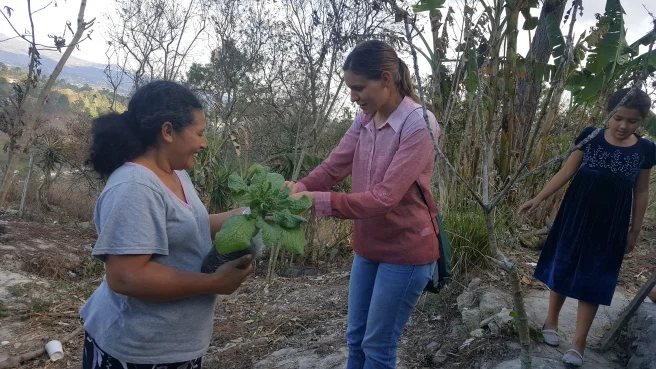 Adria Gamez helping a woman in her vegetable garden