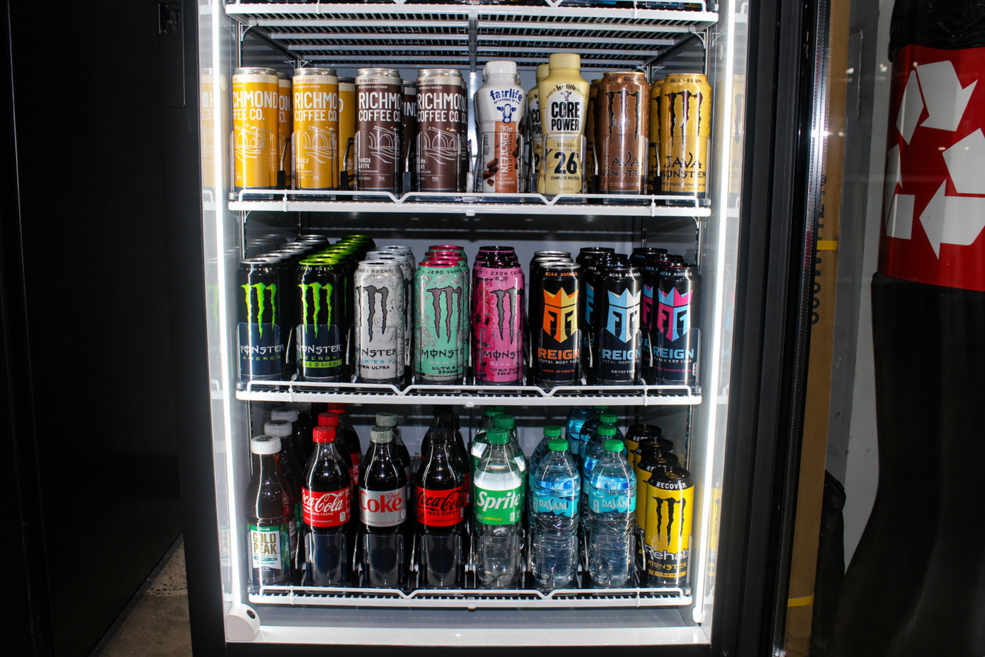 A vending machine stocked with energy drinks, soda bottles, and water bottles.