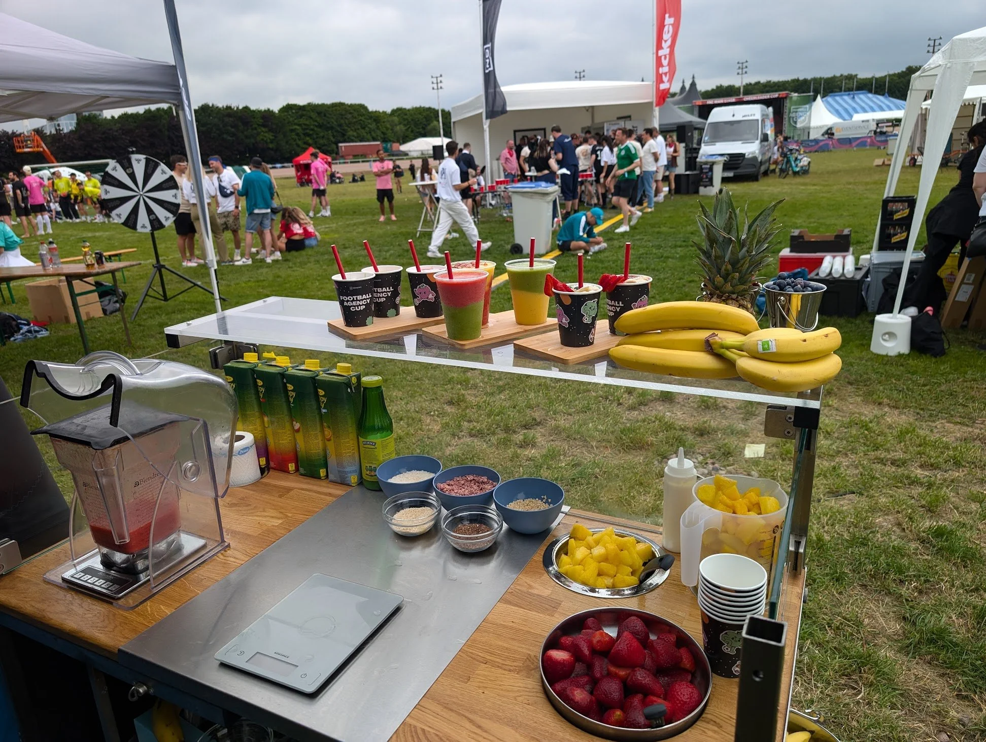 Bunte Smoothies, frisches Obst und Getränke bei einem Outdoor-Festival.