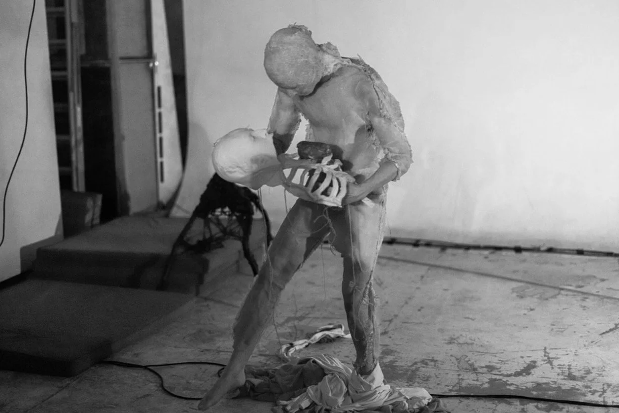 Black and white sculpture of a person holding a baby.