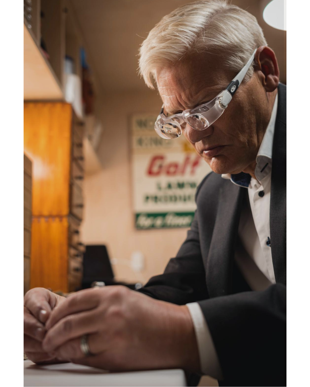 Watch specialist at work, focused on detailed assessment in a private setting.