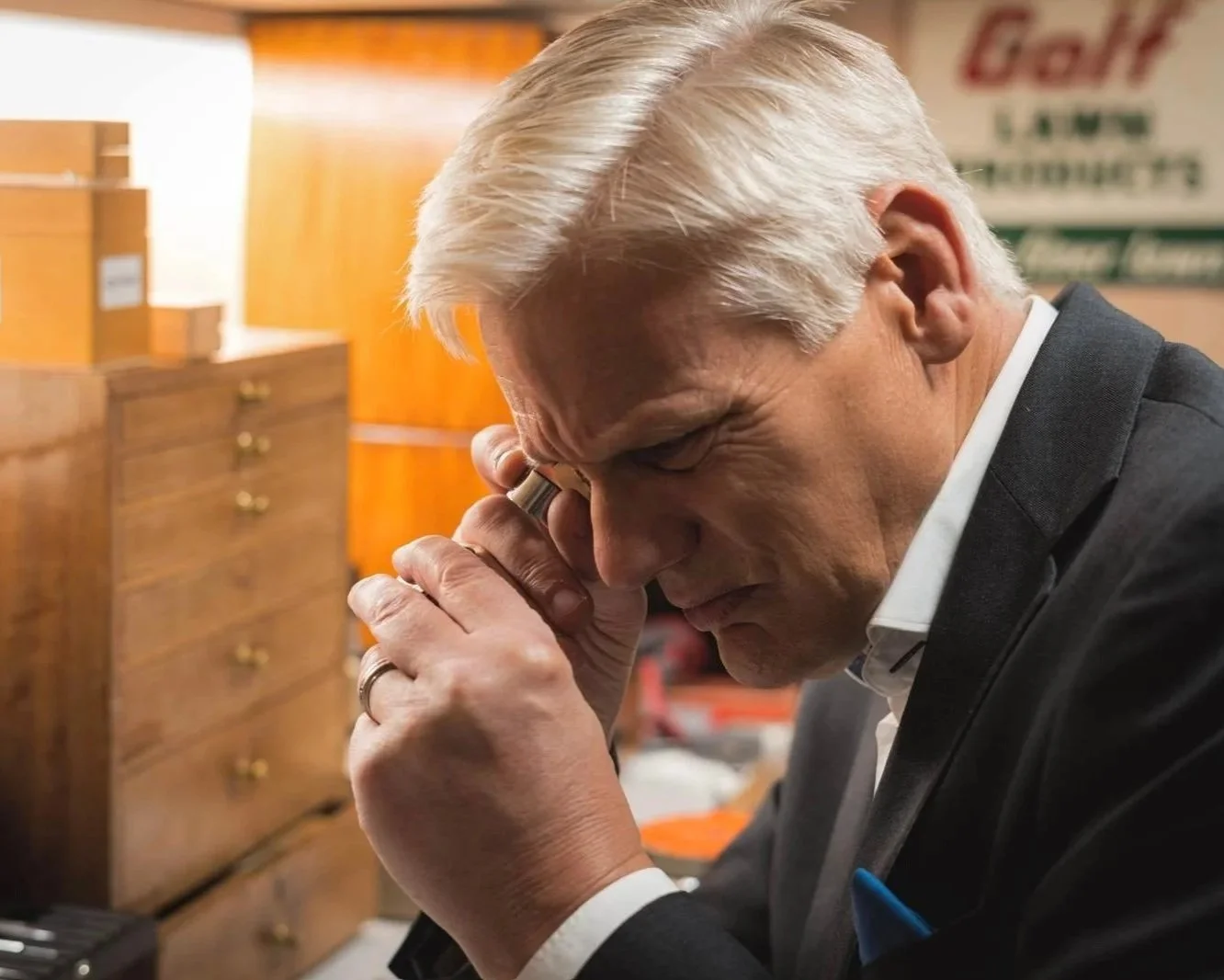 Watch specialist in a moment of reflection within a private workspace.