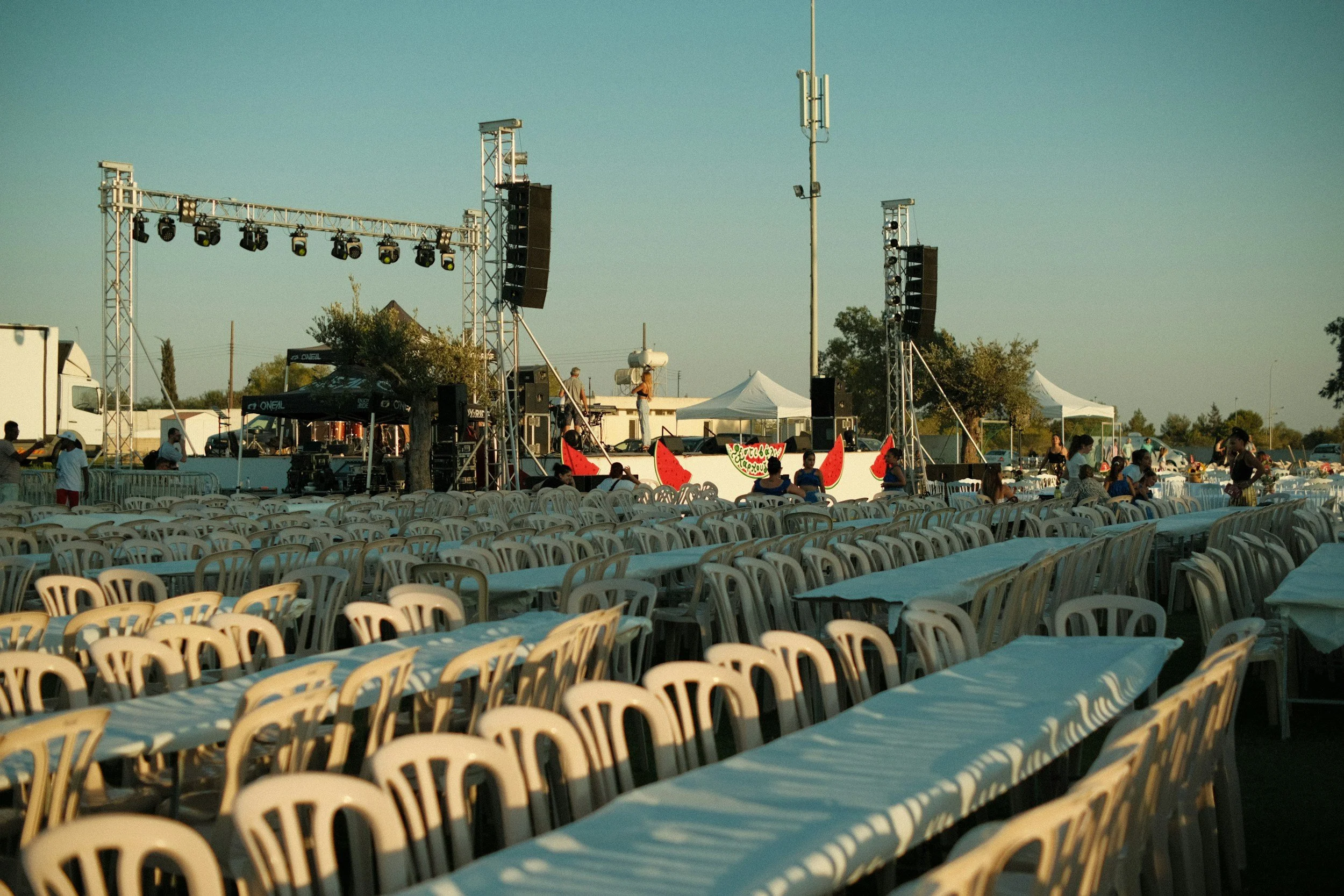 Outdoor event stage with lighting and sound equipment being prepared before guests arrive.