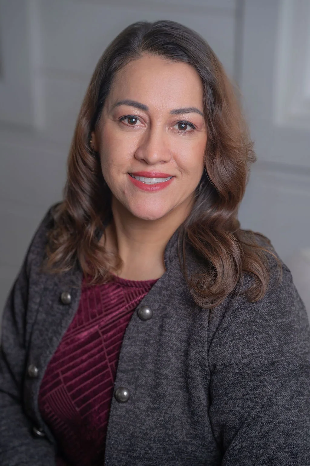 Professional corporate headshot of board member smiling in a bright modern office.