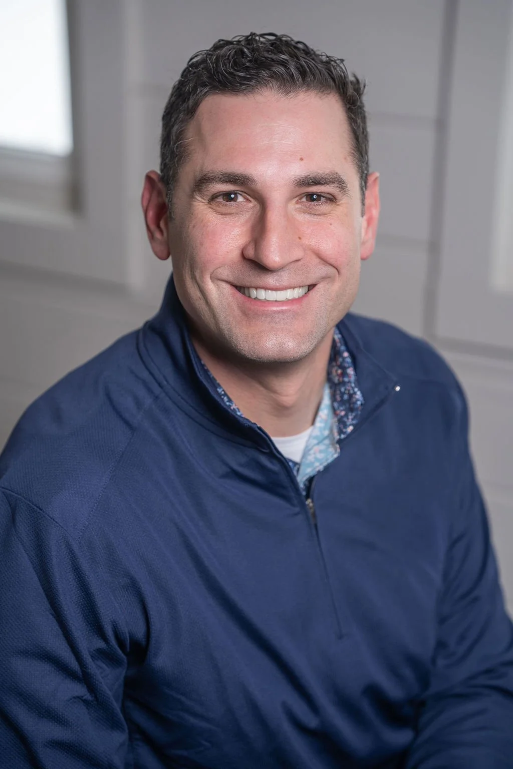 Professional corporate headshot of board member smiling in a bright modern office.