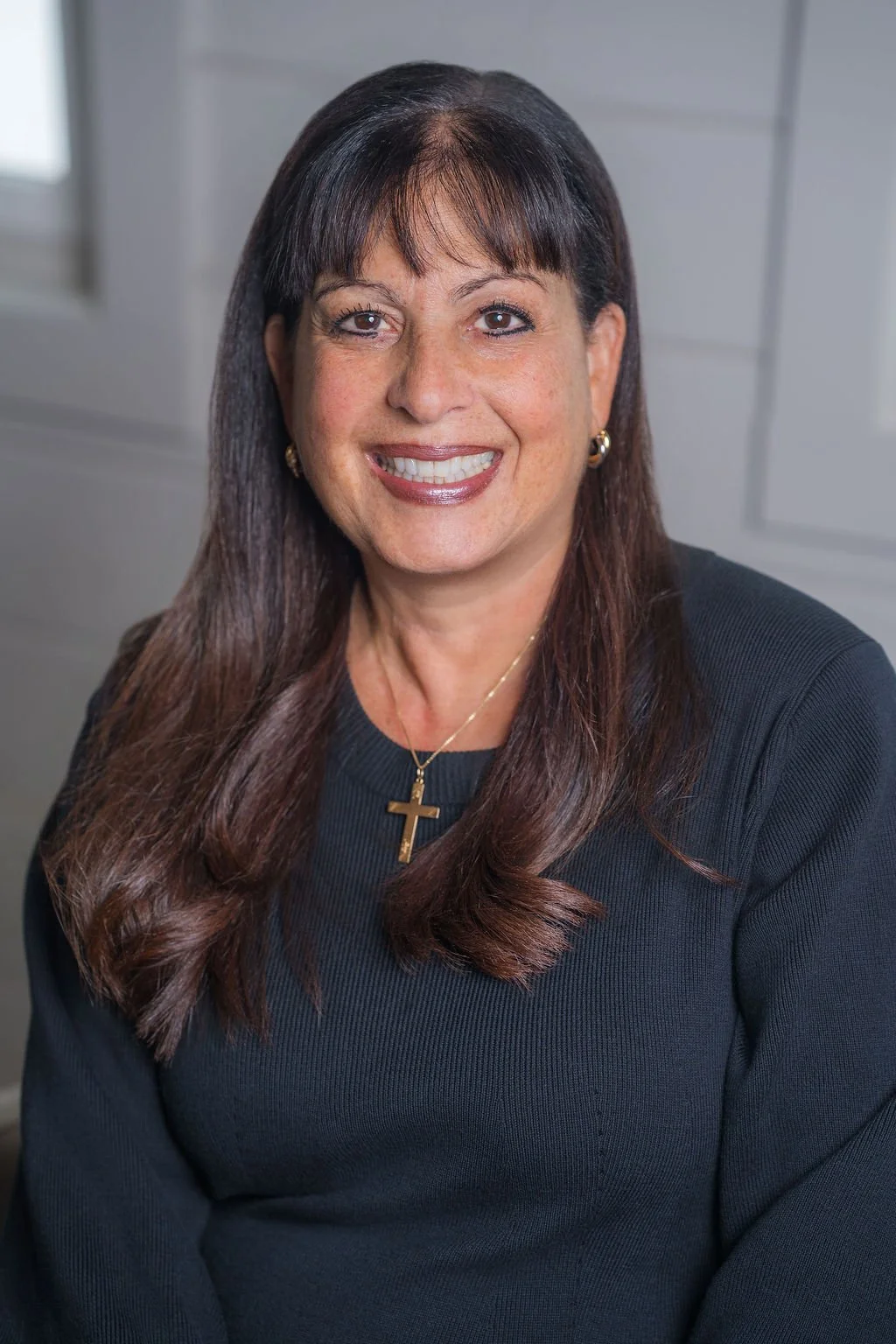 Professional corporate headshot of board member smiling in a bright modern office.