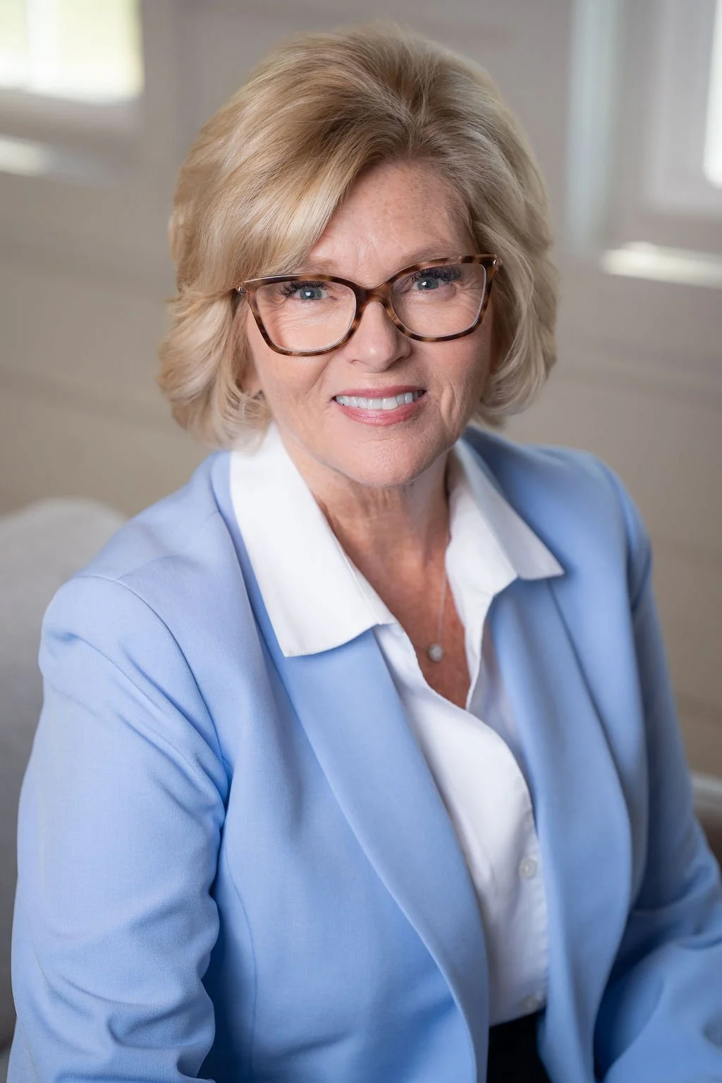 Professional corporate headshot of board member smiling in a bright modern office.