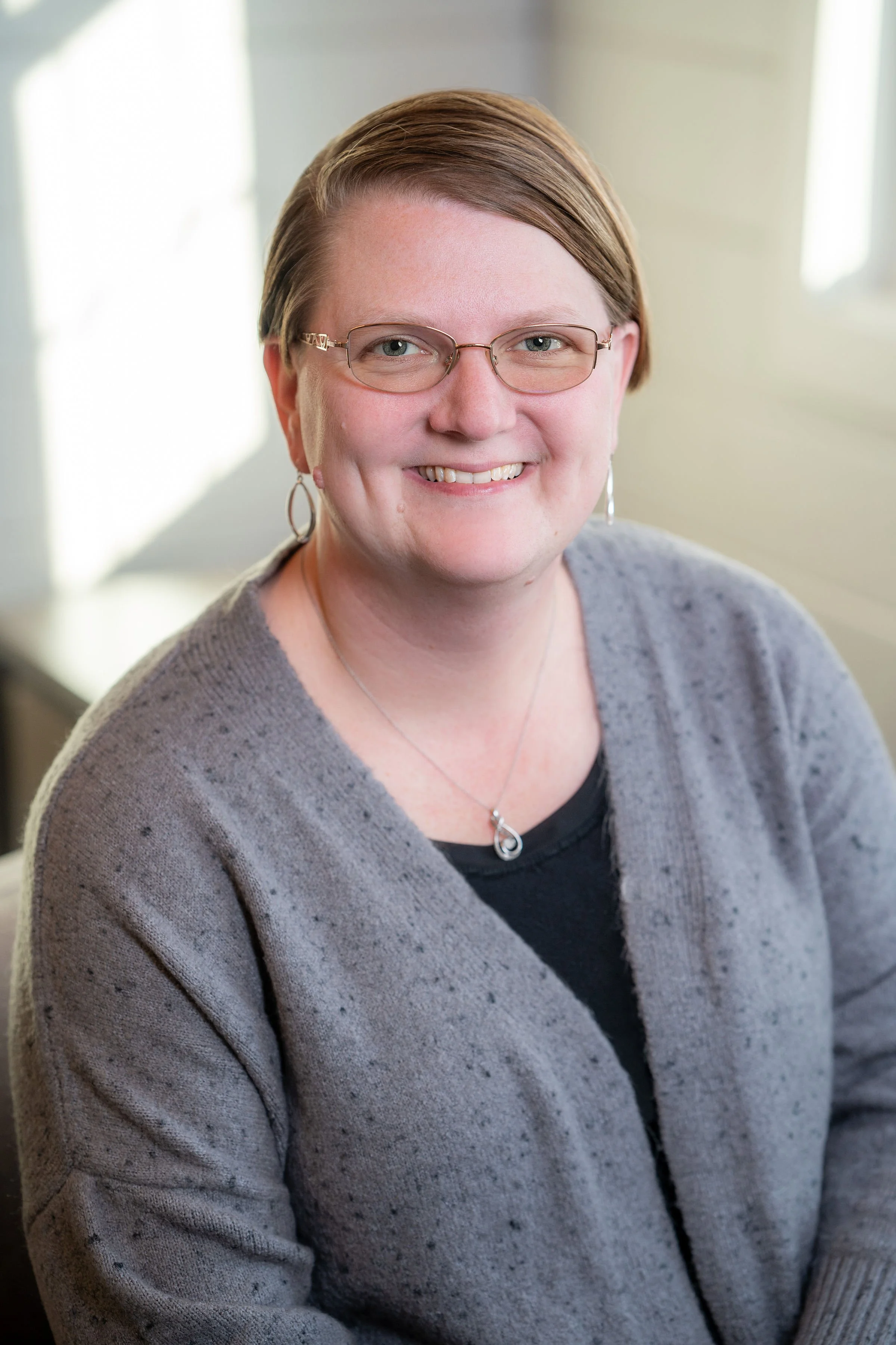 Professional corporate headshot of board member smiling in a bright modern office.