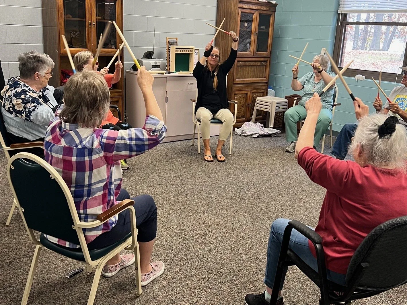 Senior home following drumming instructor in a circle