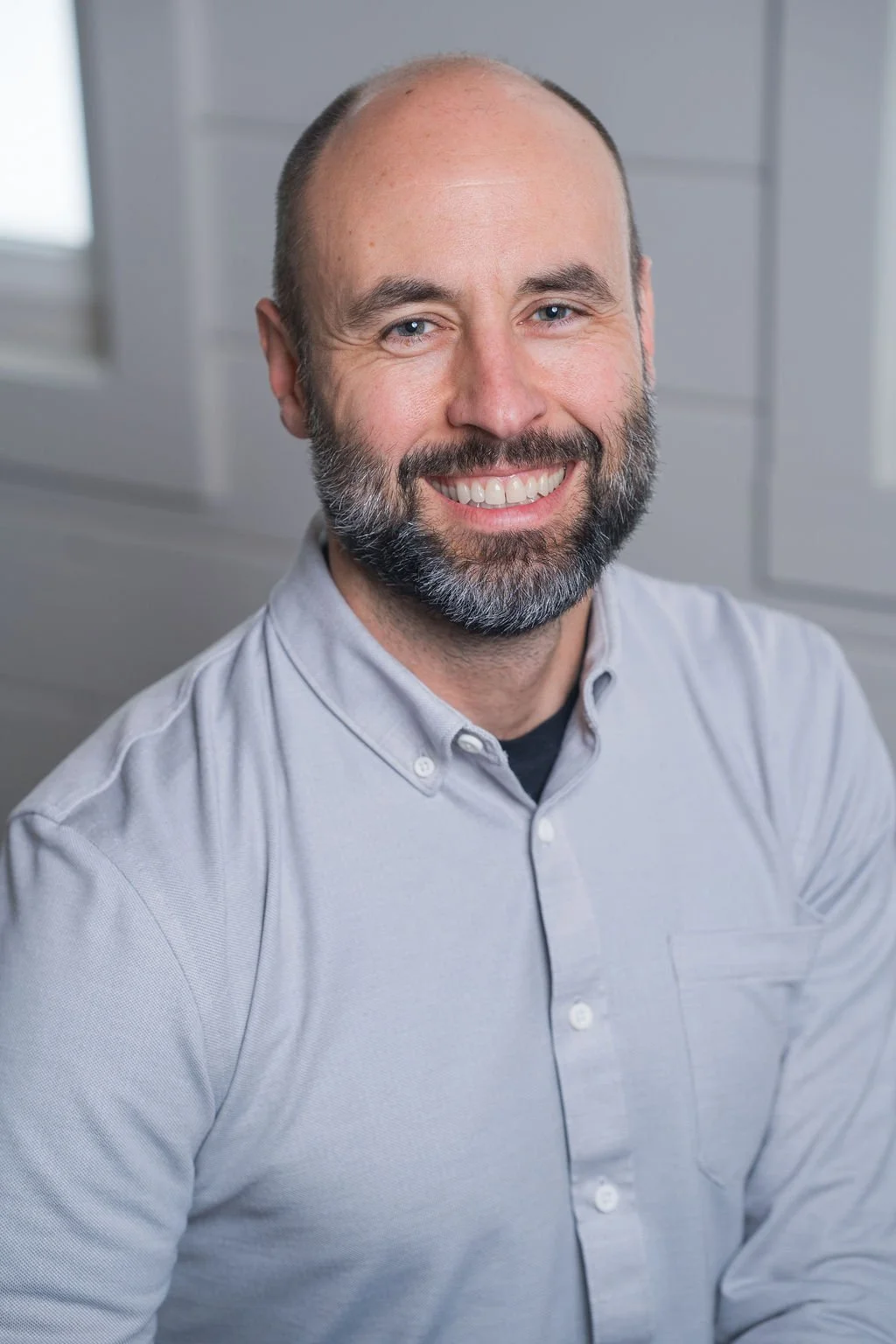Professional corporate headshot of board member smiling in a bright modern office.