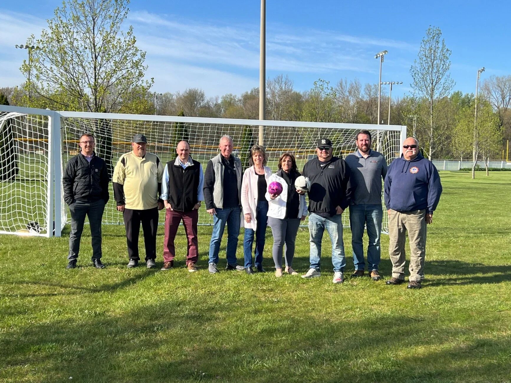 CCAC board and staff and the K21 Health Foundation staff posing in front of a soccer goal