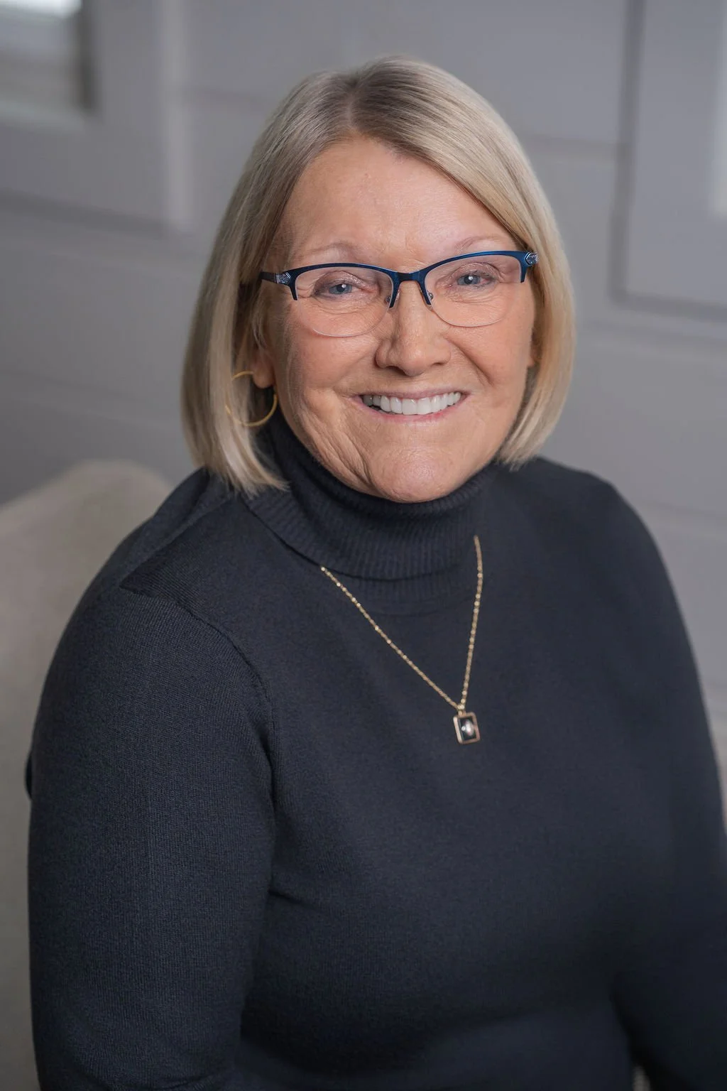 Professional corporate headshot of board member smiling in a bright modern office.