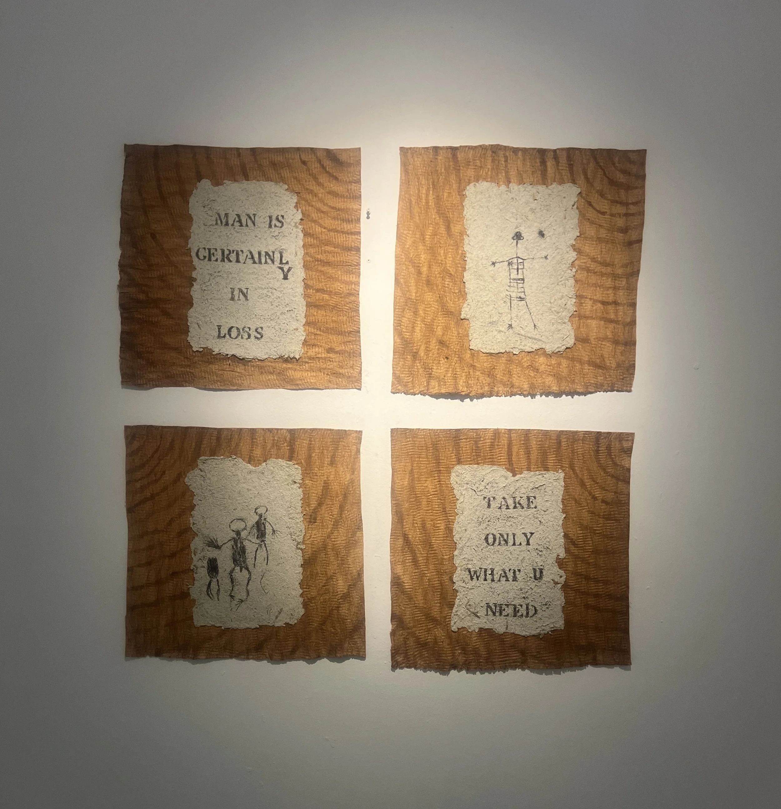 Four torn pieces of paper with hand-drawn illustrations and text, attached to a wall with a light shining from behind.