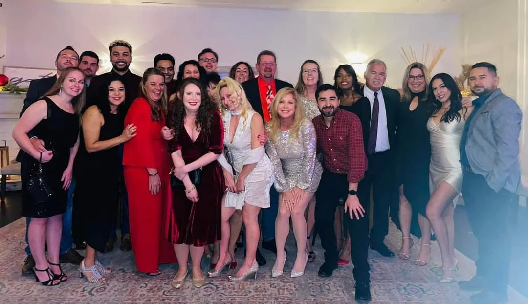 Group of people in formal attire posing for a photo indoors at a celebration or event.