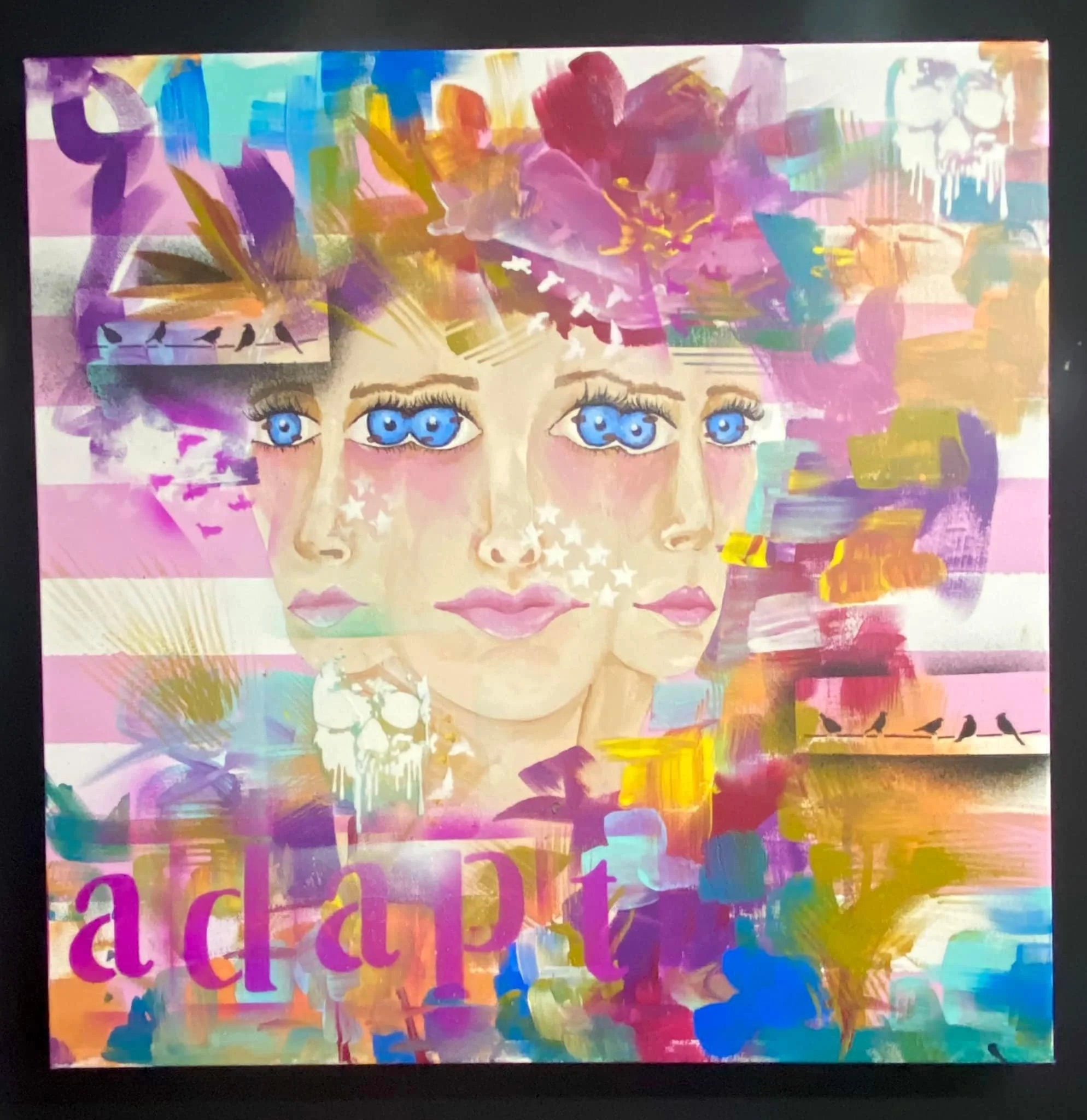 Colorful abstract artwork featuring a face with bright blue eyes, surrounded by vibrant brushstrokes in pink, purple, yellow, green, and blue, with some black birds and white star-like accents.