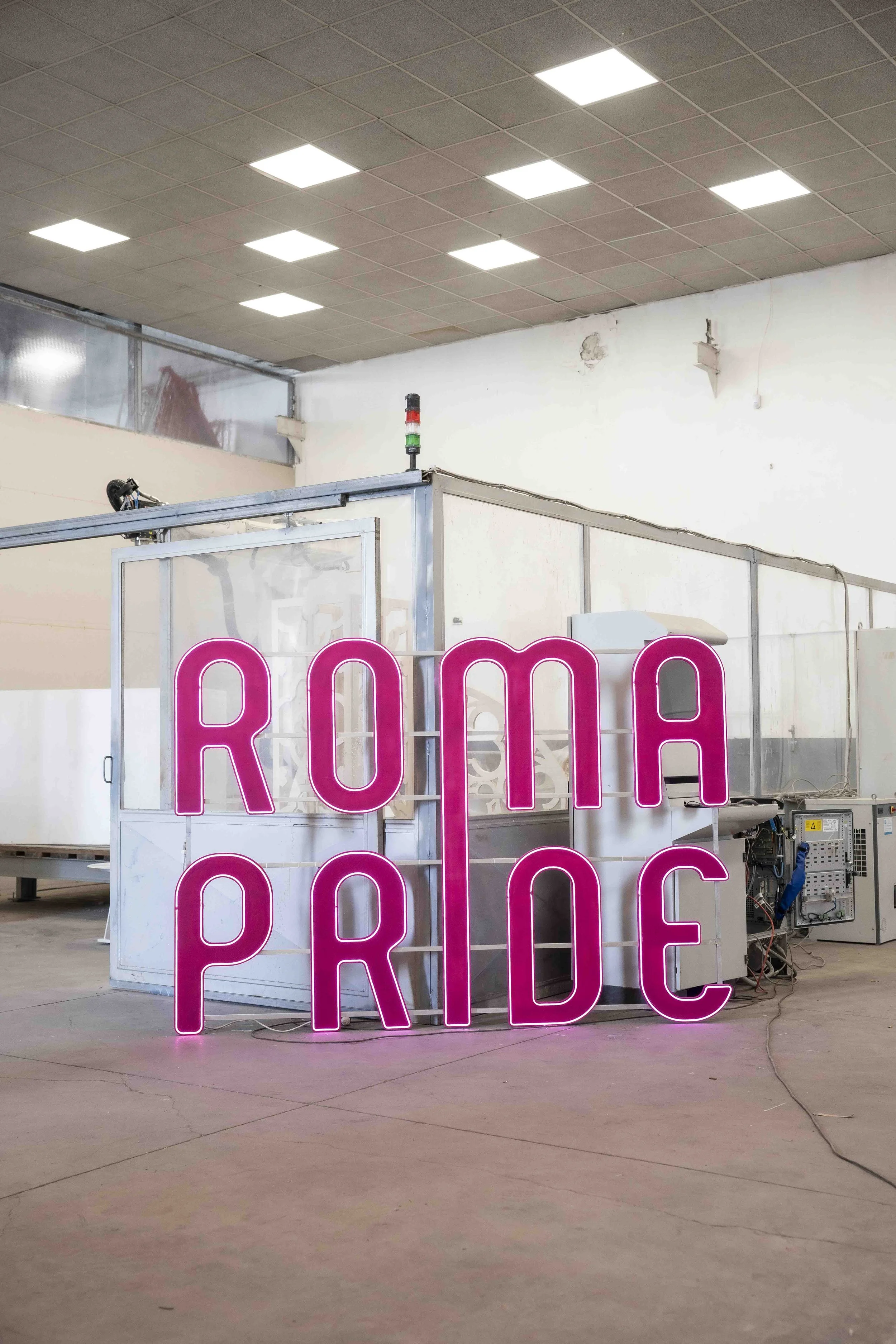 Neon sign spelling out the word 'PARADE' amid carnival lights and a crowd of festival-goers at nighttime.