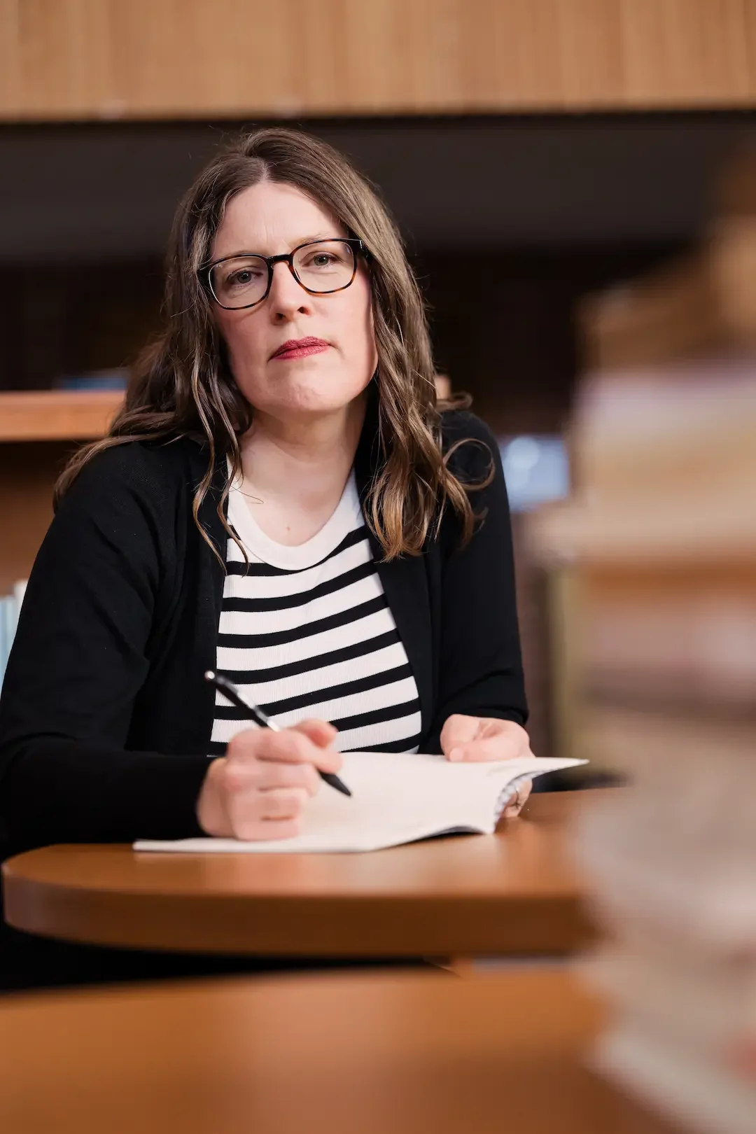 Sarah L Sanderson sitting at a table with a pen and journal