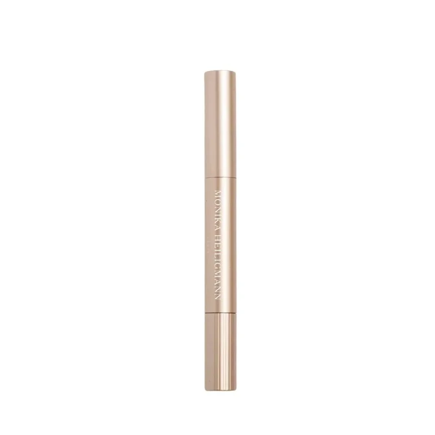 A gold-colored tube of Monika Helgermann cosmetic product, standing vertically against a white background.