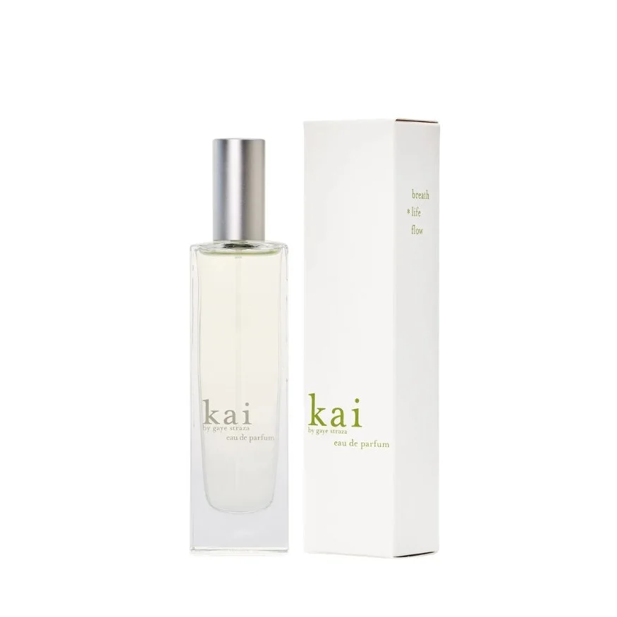 A clear glass perfume bottle with the label 'kai by gaye straza eau de parfum' next to a white box with green text that reads 'kai by gaye straza.'
