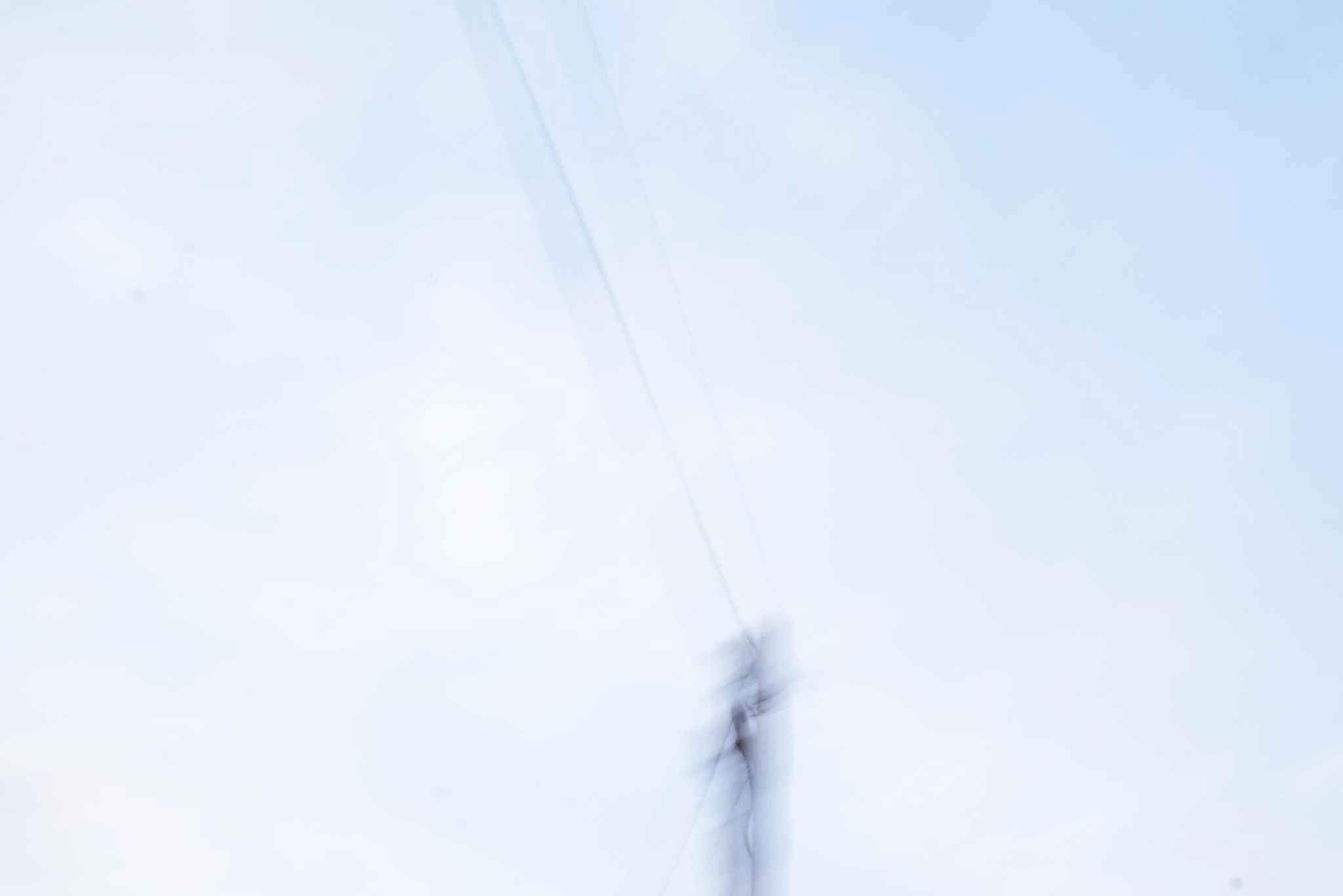 A close-up view of a power line pole against a cloudy sky, showing wires and insulators. West Cork. Abstract art