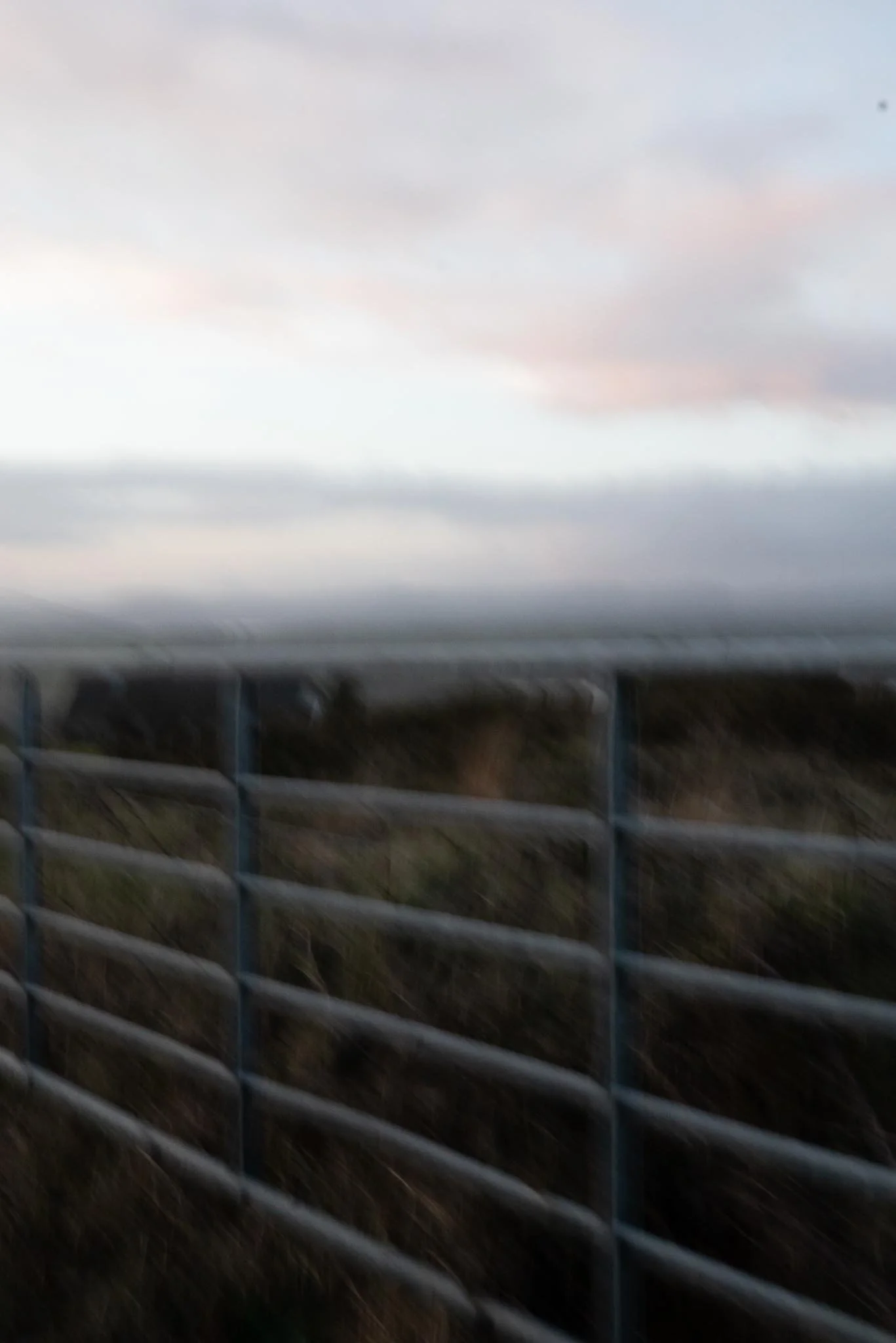Cloudy sky above a bridge with a metal railing in the foreground. West Cork. Abstract art