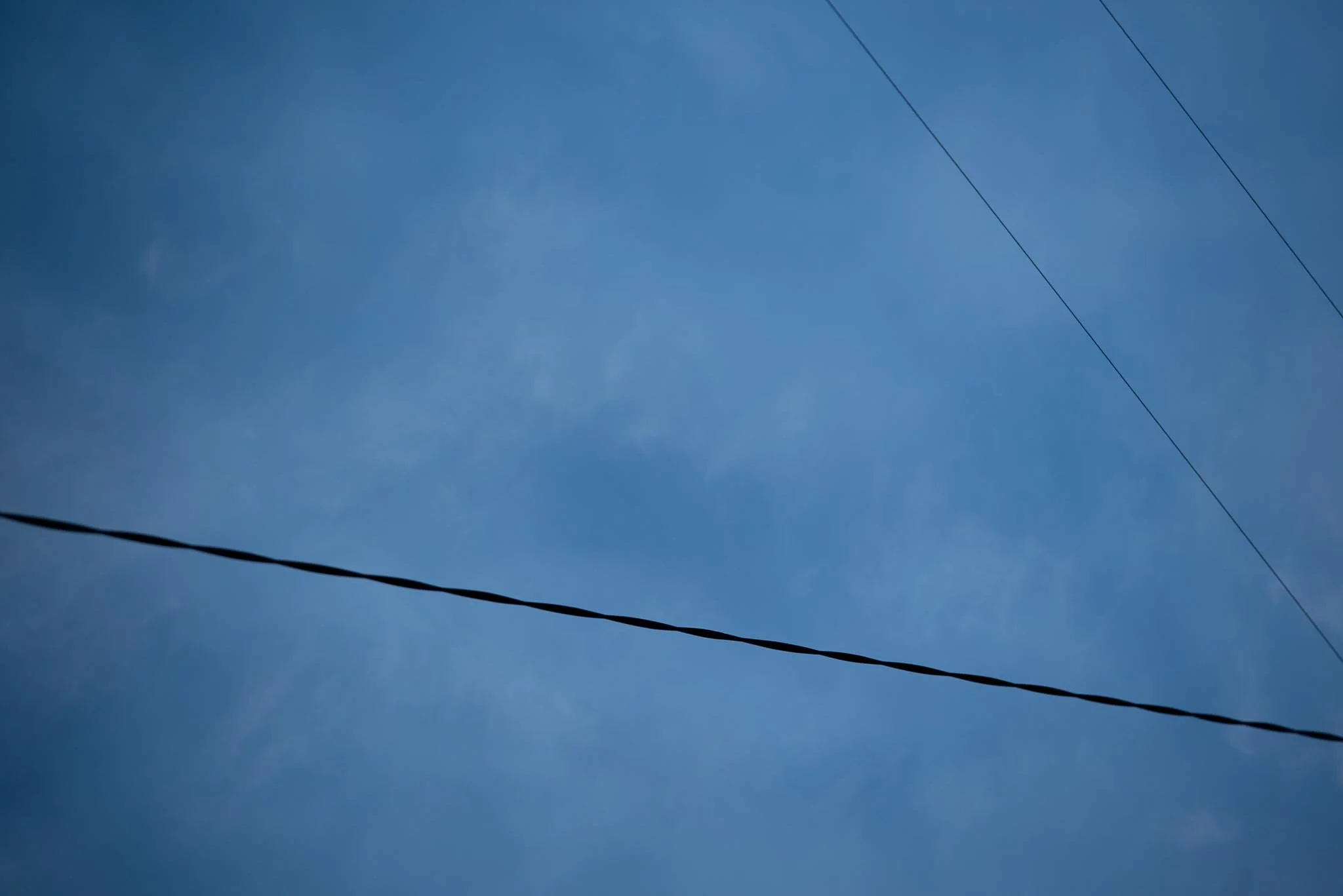 Clear blue sky with three power lines crossing the image. West Cork. Abstract art