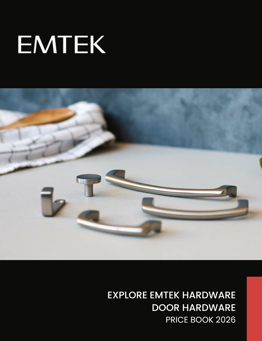 A collection of metallic door handles and hardware pieces laid out on a flat surface with a bed and checkered linens in the background, part of a catalog cover for EMTEK hardware.