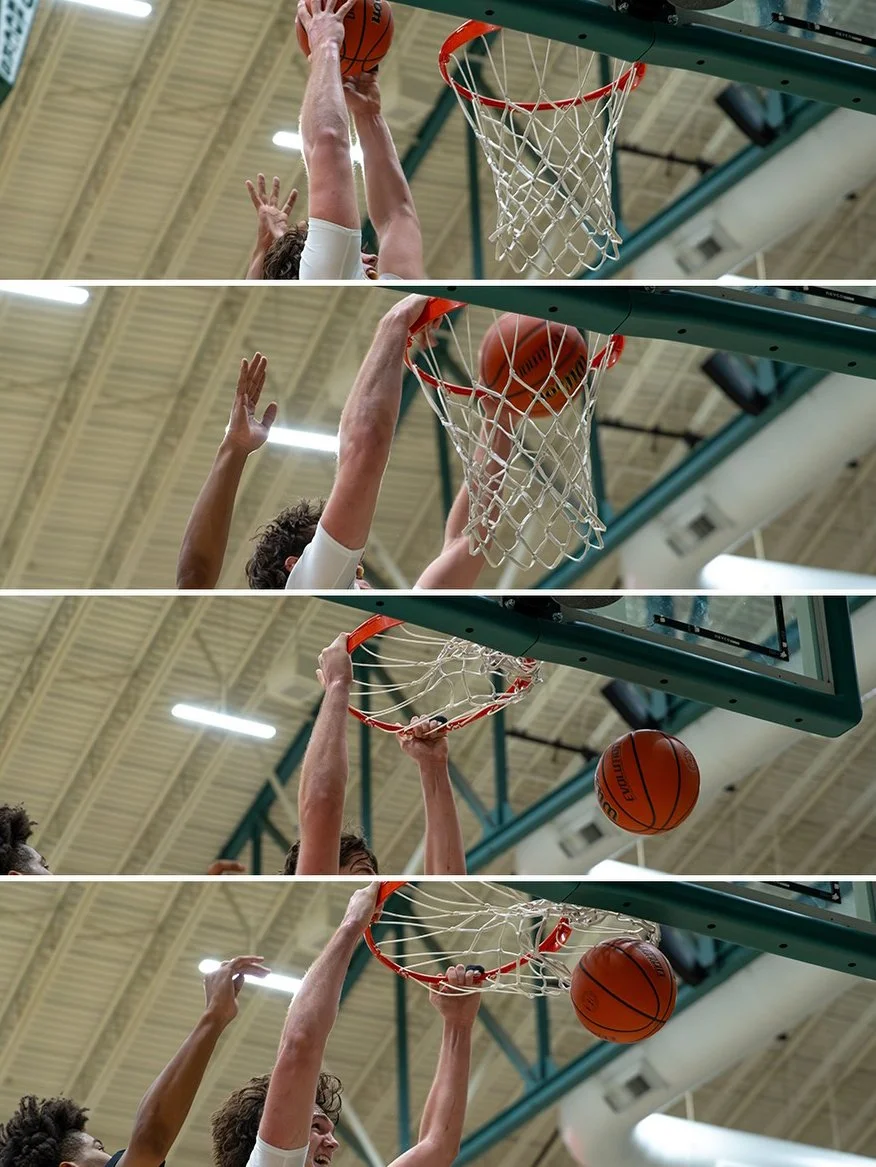 A basketball player is dunking the ball into the hoop in a gymnasium.