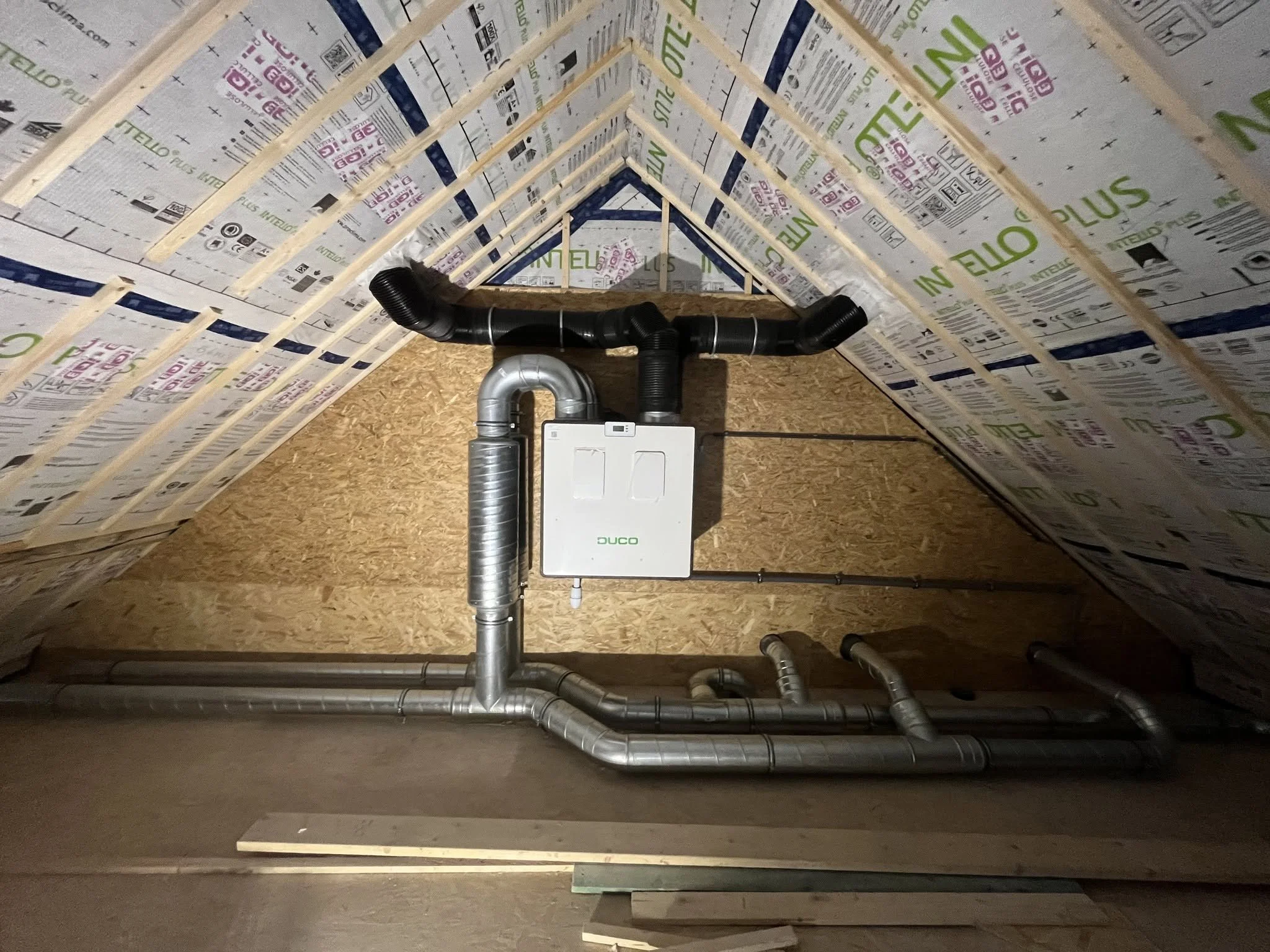 Installation de plomberie avec des tuyaux en acier inoxydable et un système de ventilation dans un espace en construction ou rénovation