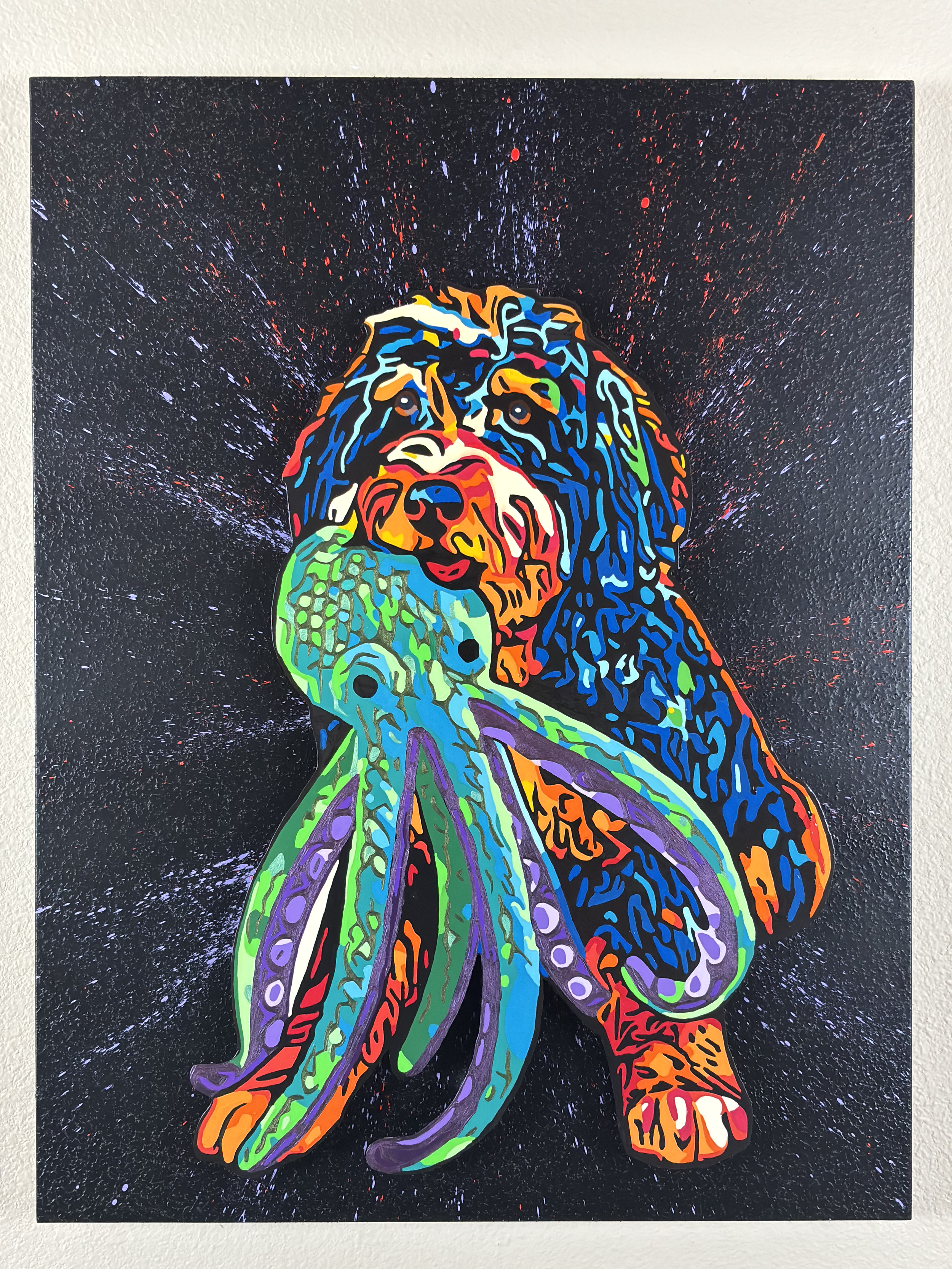 Painted artwork of a dog with colorful neon-like patterns, holding an octopus in its mouth against a black background with splattering red and white paint effects.