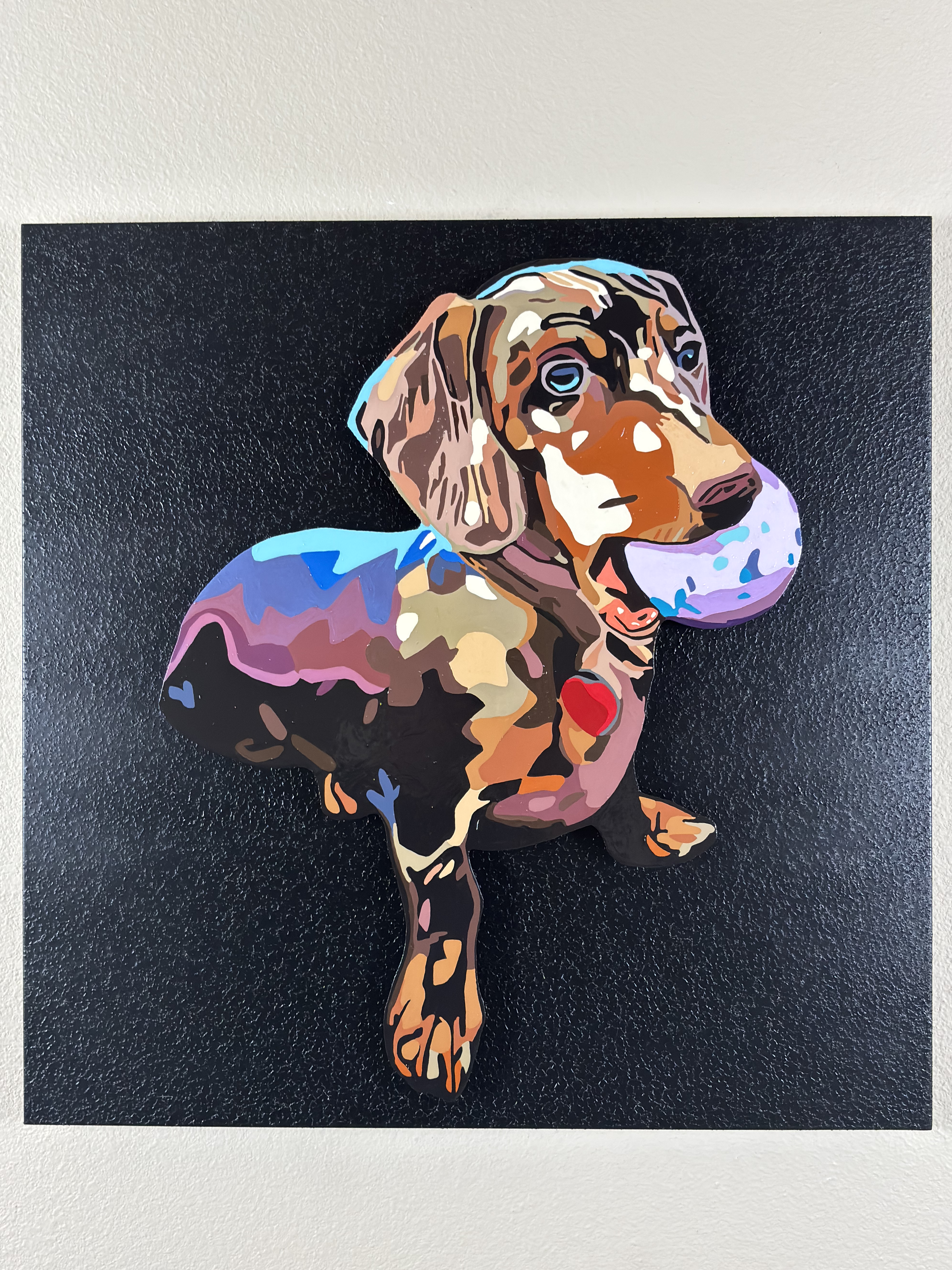 Colorful painting of a dachshund dog with a ball in its mouth on a black textured background.