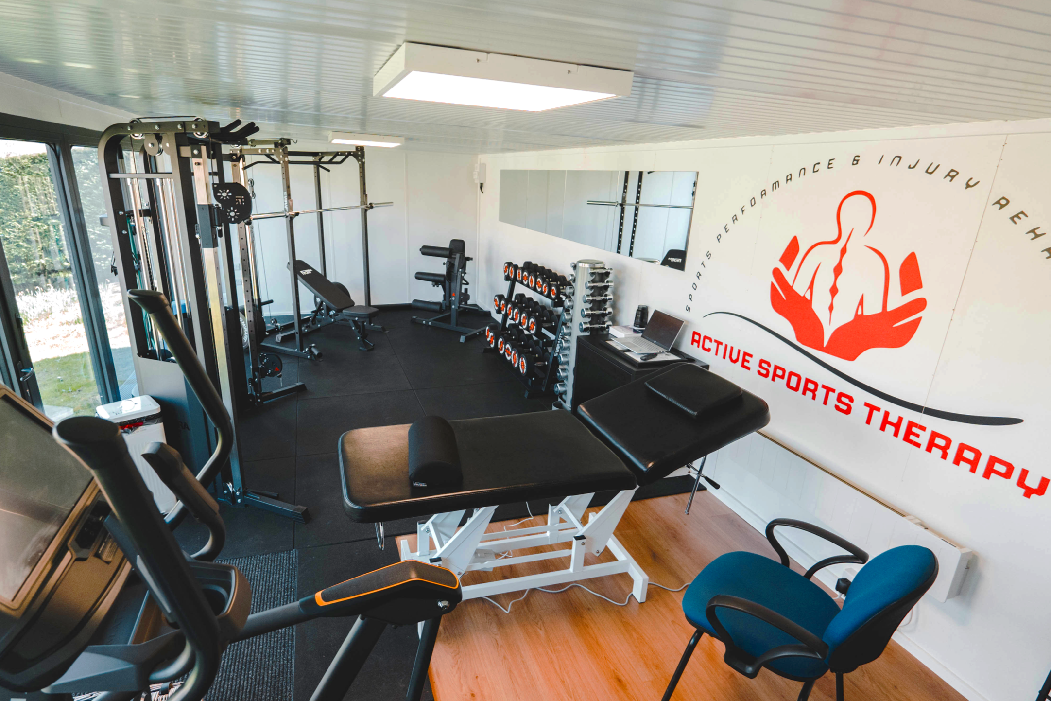 Interior of a gym or fitness studio with workout equipment and motivational signage on the wall.