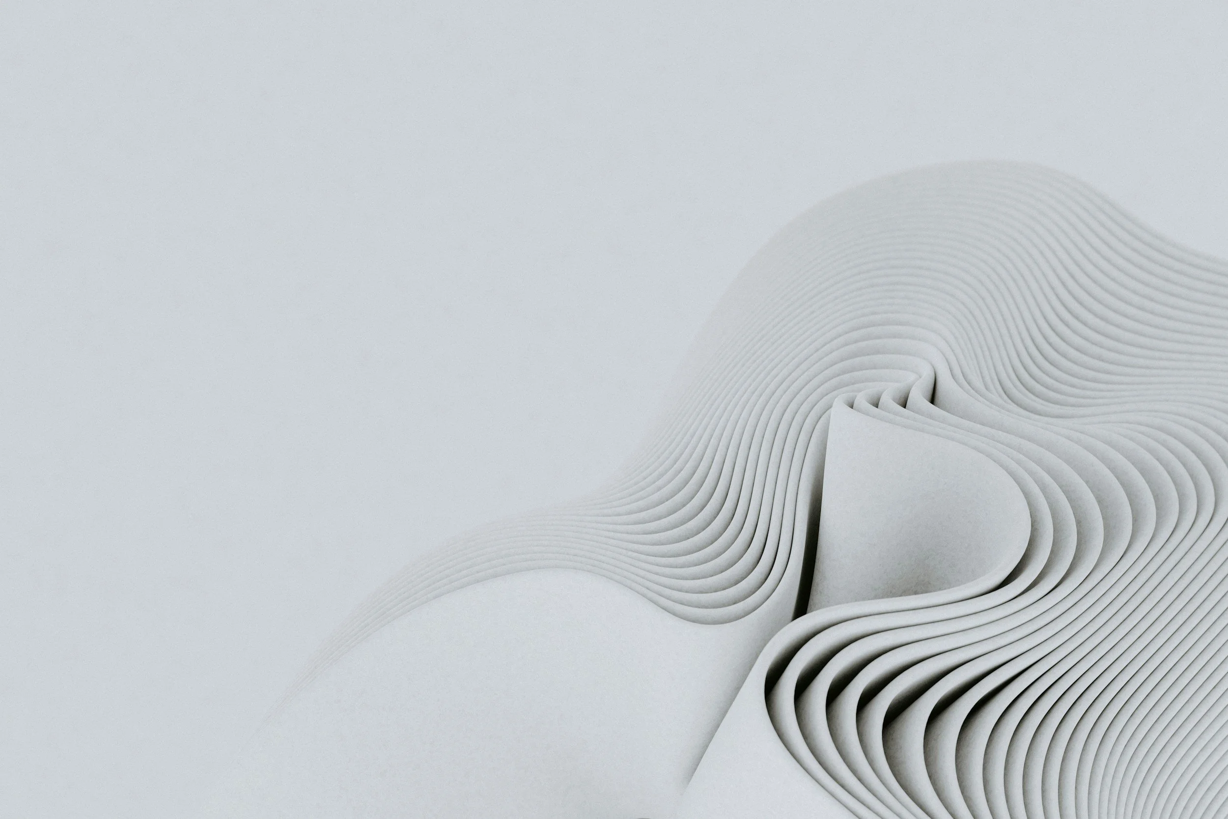 Close-up of layered, curved white paper shapes creating an abstract, flowing pattern.