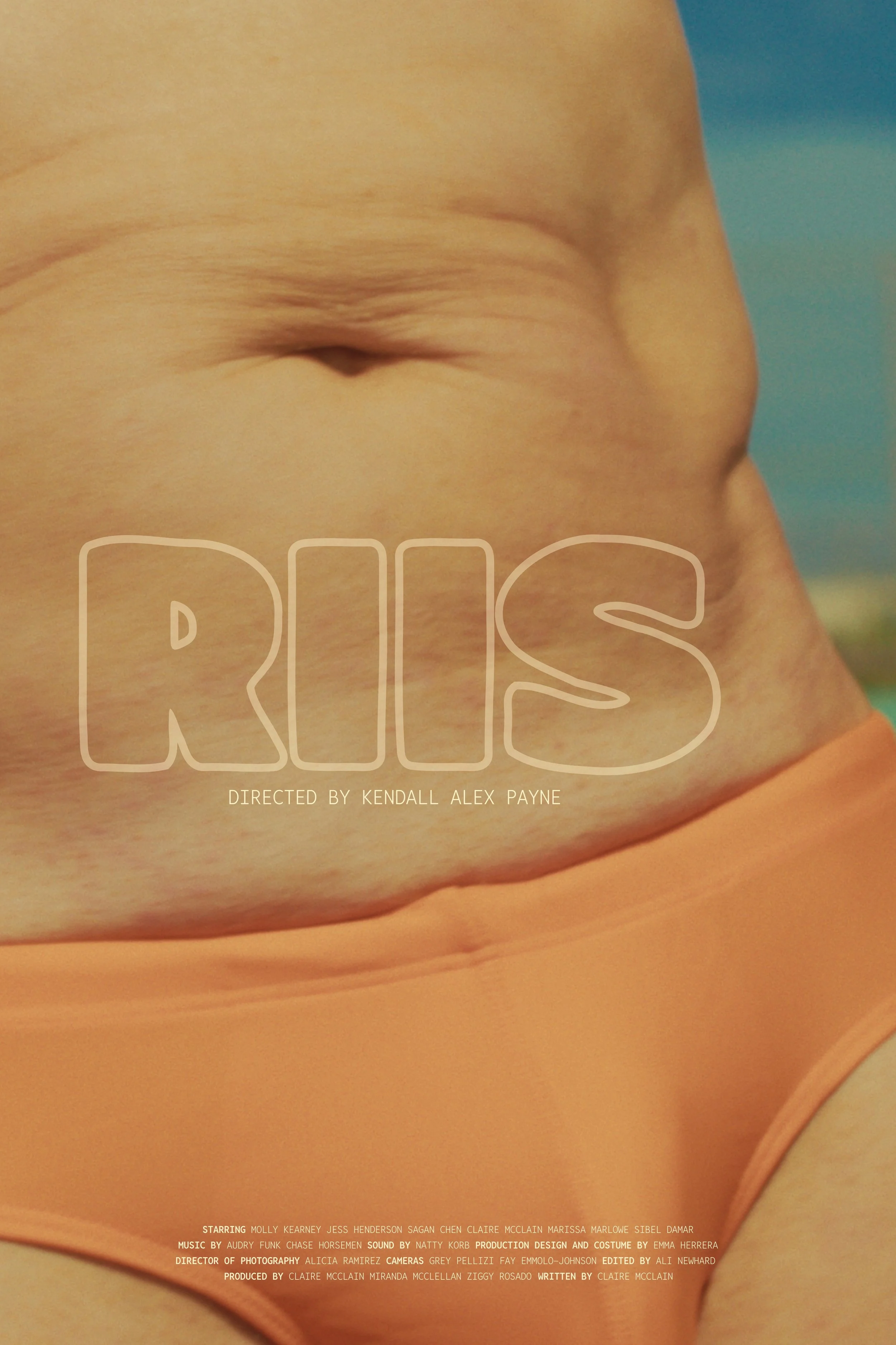 Close-up of a person's midsection with a tanned belly and navel, wearing orange underwear, with the words 'RIIIS' and credits overlaid.