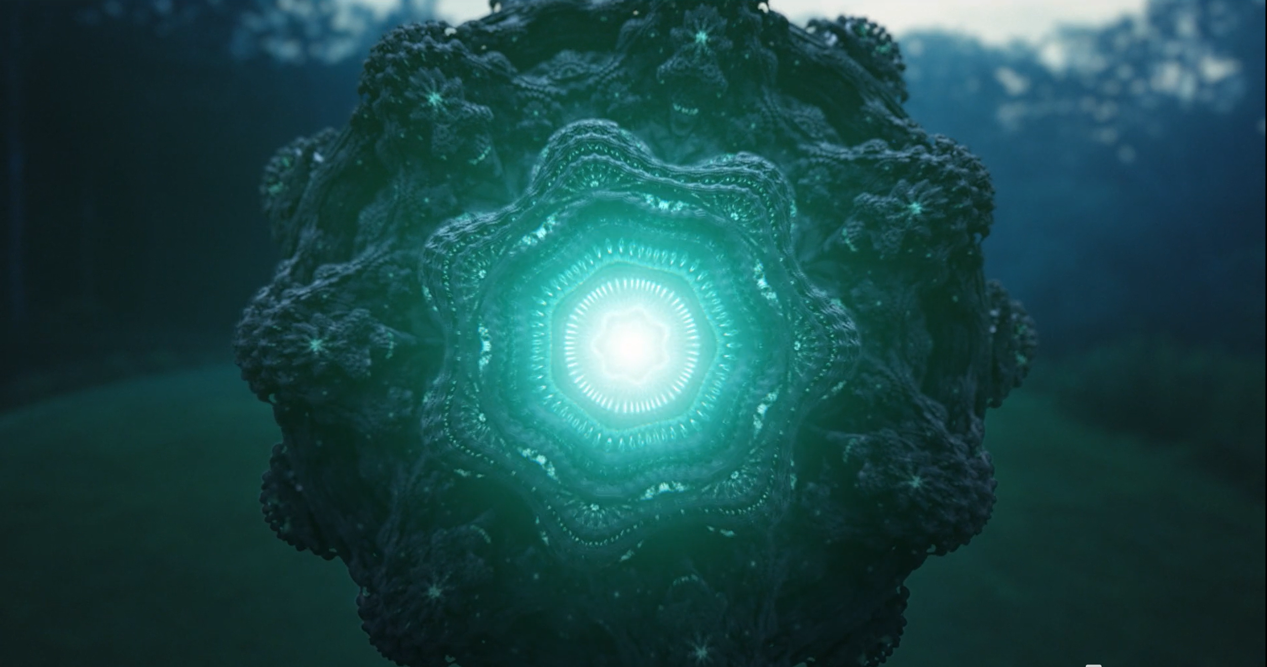 A glowing, intricate geometric structure with a bright center, resembling a luminescent star or flower, surrounded by detailed, textured patterns in shades of blue and teal, set against a blurred natural background.