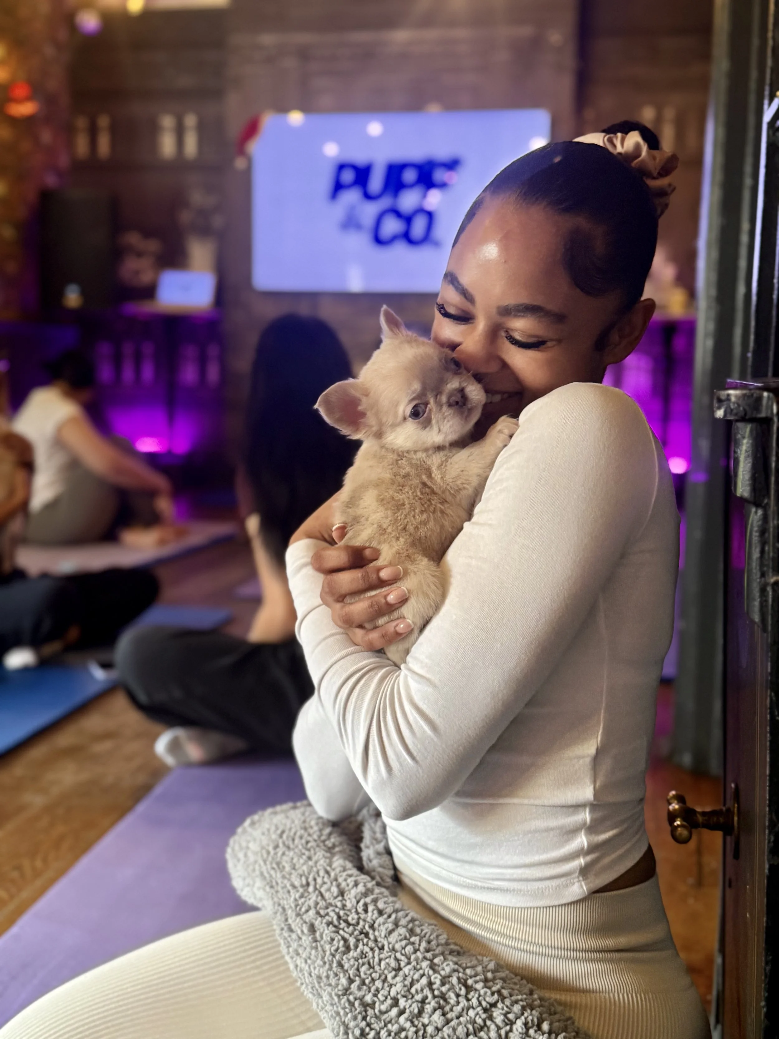 Woman smiling and cuddling a cute puppy