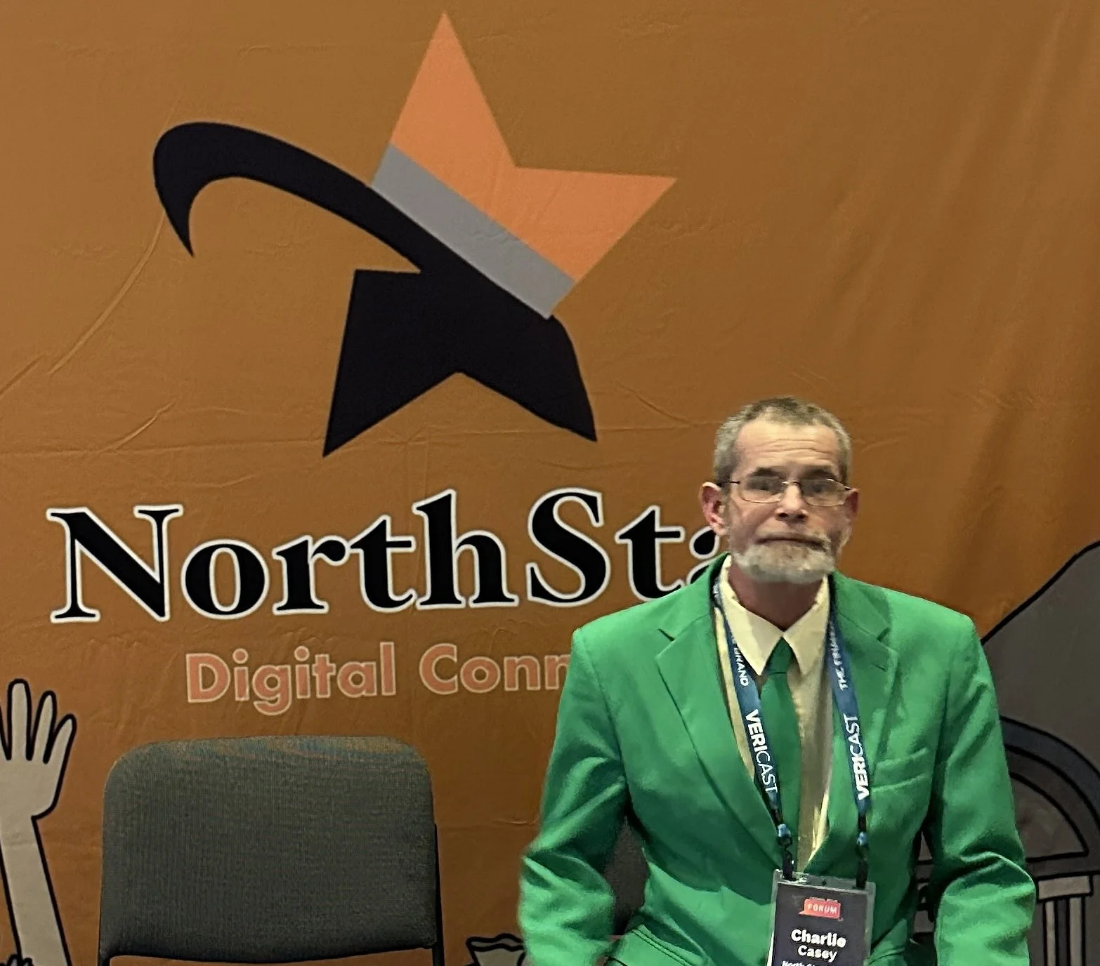 Person in a green suit sitting in front of a banner with NorthStar Logo