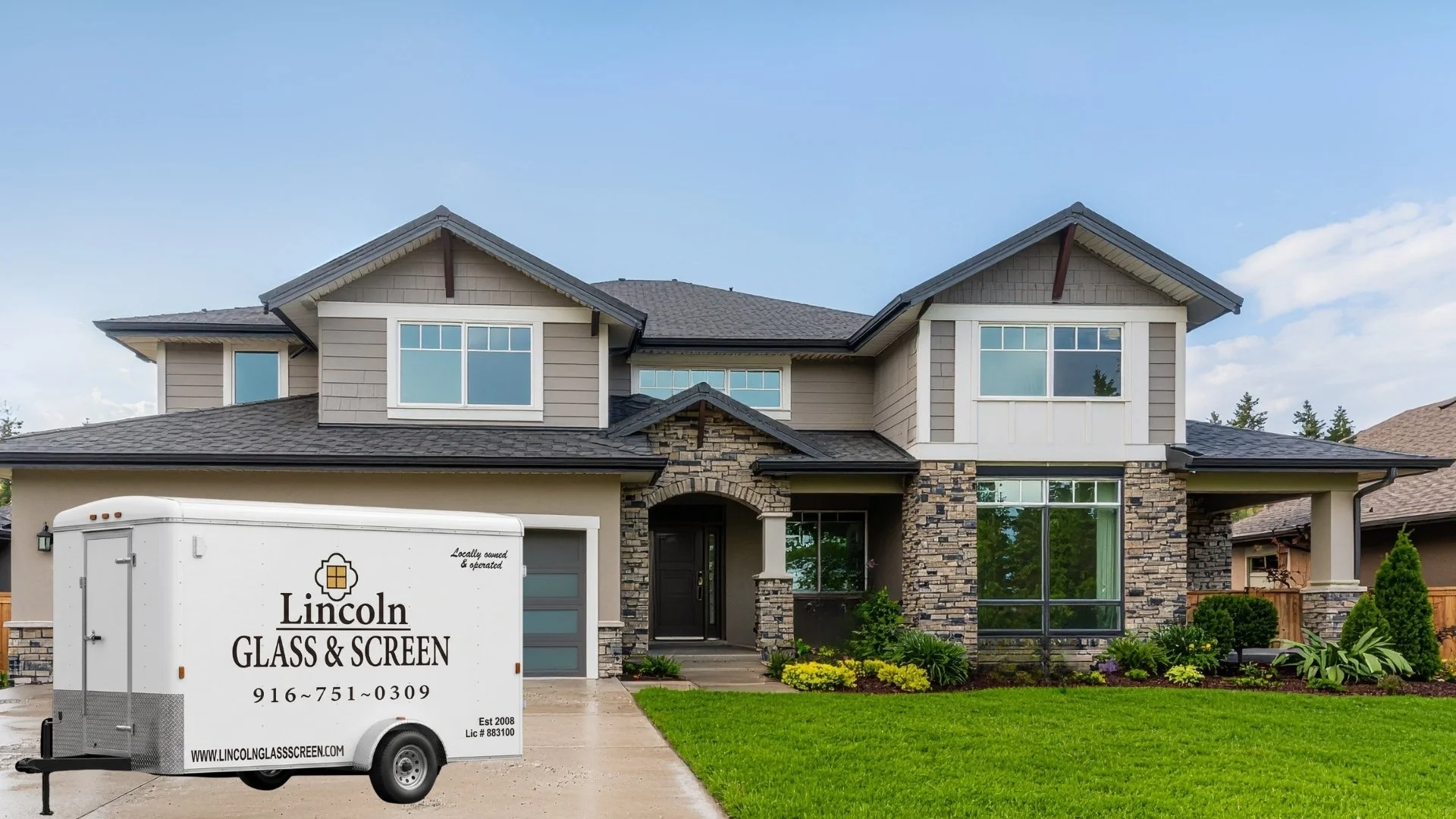 A modern two-story house with a manicured lawn, stone and siding exterior, large front windows, and a black front door. There is a white trailer with black lettering that reads 'Lincoln Glass & Screen' parked in the driveway.