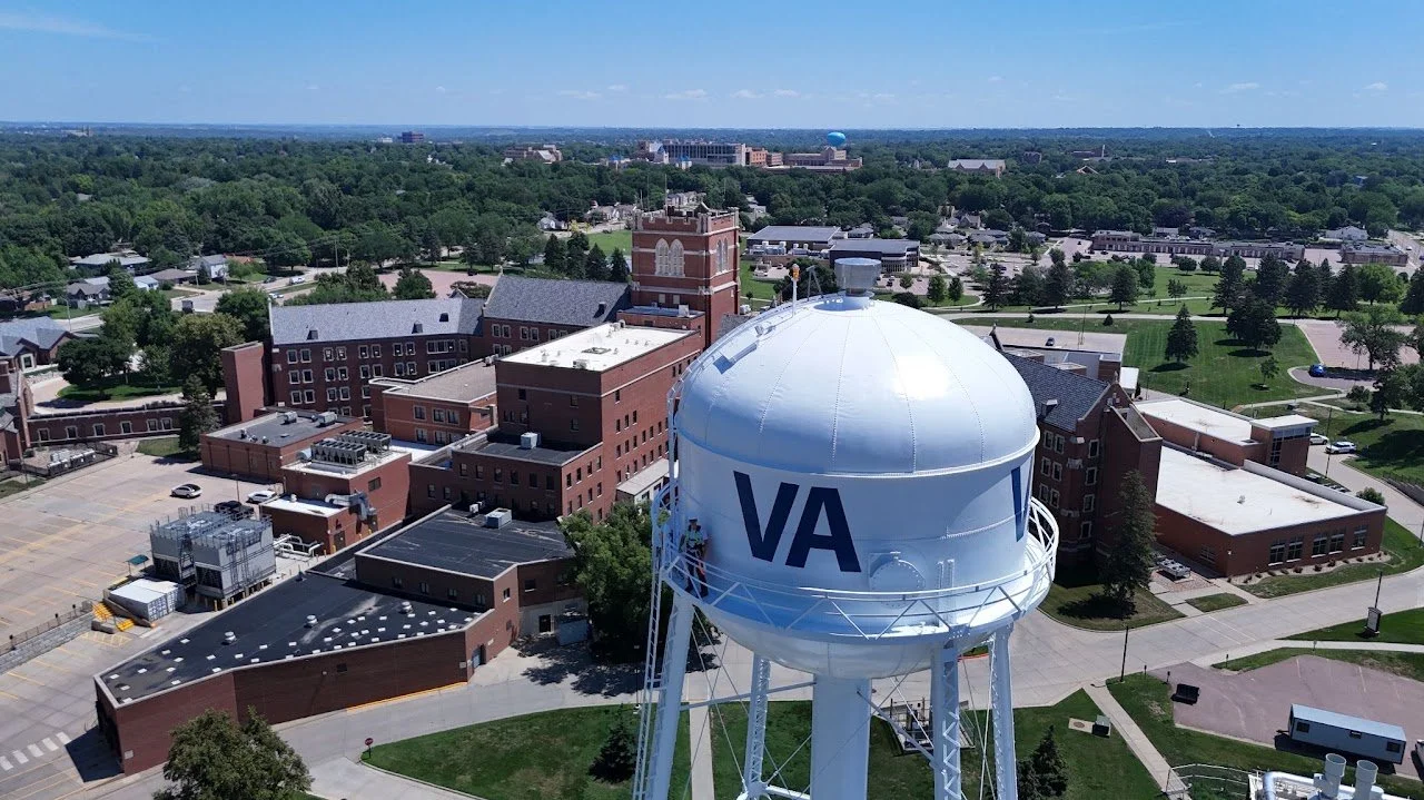 Aerial view of a town with a large water tower marked  VA