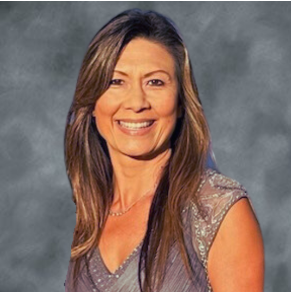 A woman with long brown hair smiling at the camera, wearing a sleeveless top with sequins.