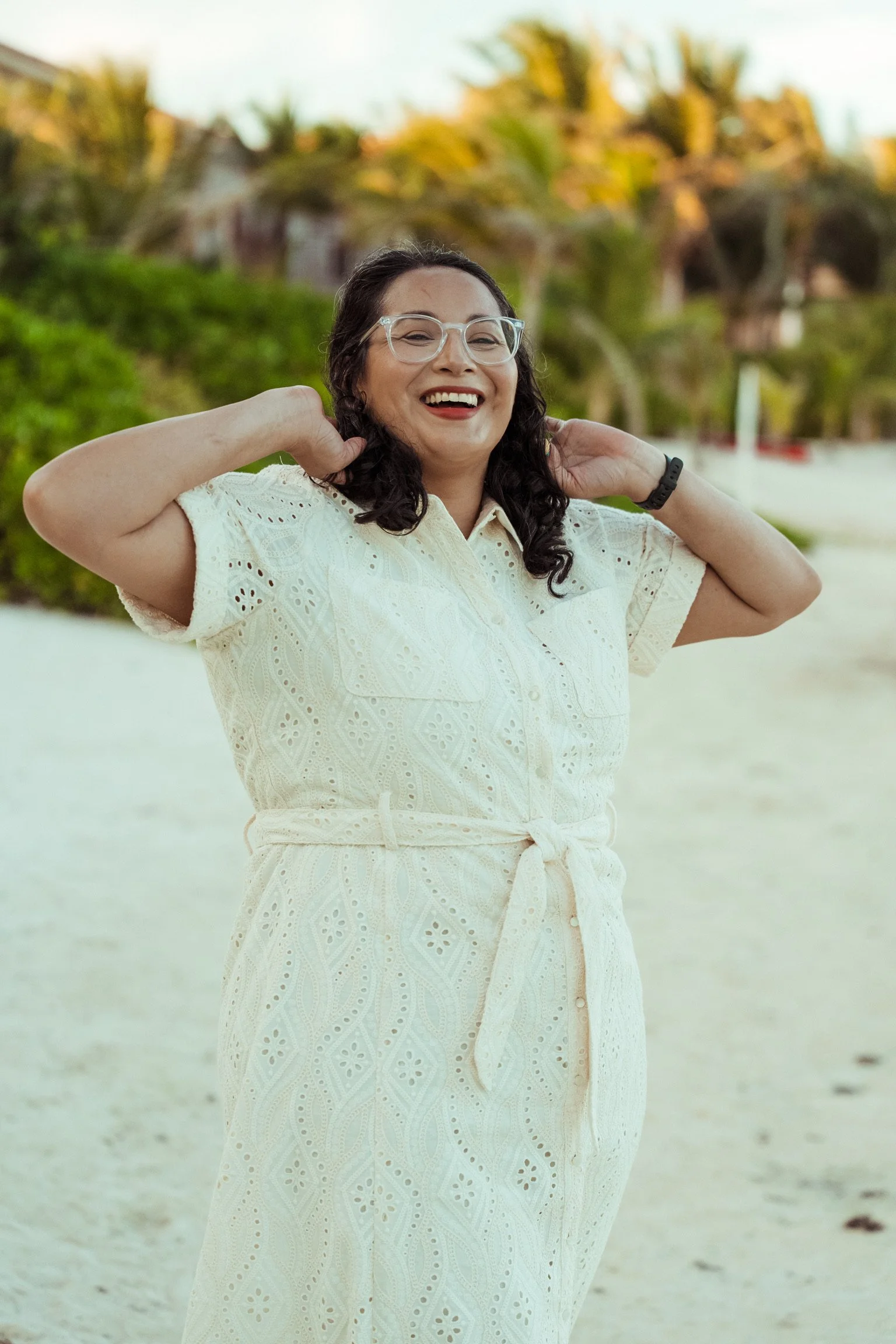 Jess Black, founder of Amatista Toro Solutions, smiling on a beach in a white dress. Atlanta-based digital marketing and MarTech consultant.