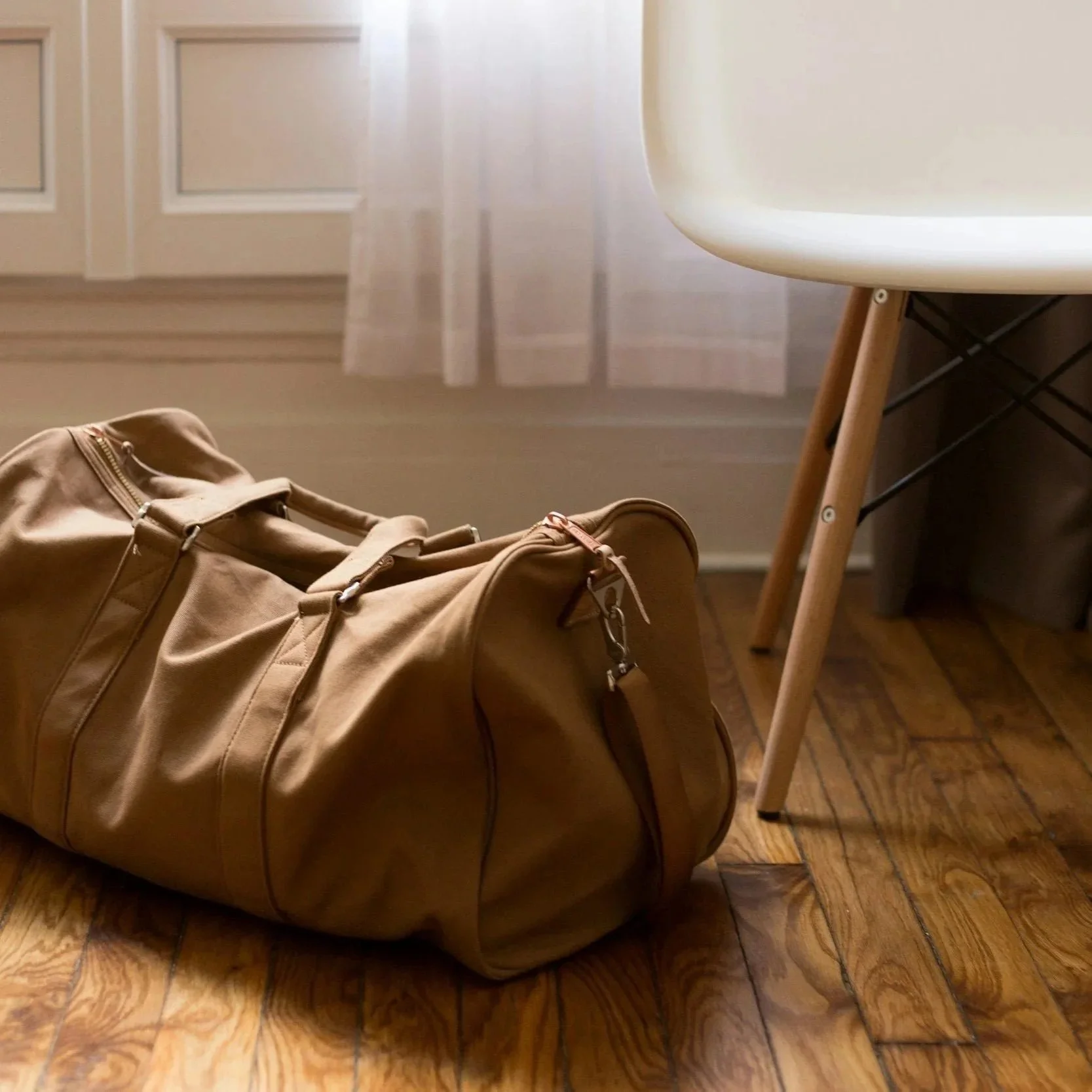 Brown bag on floor beside white chair