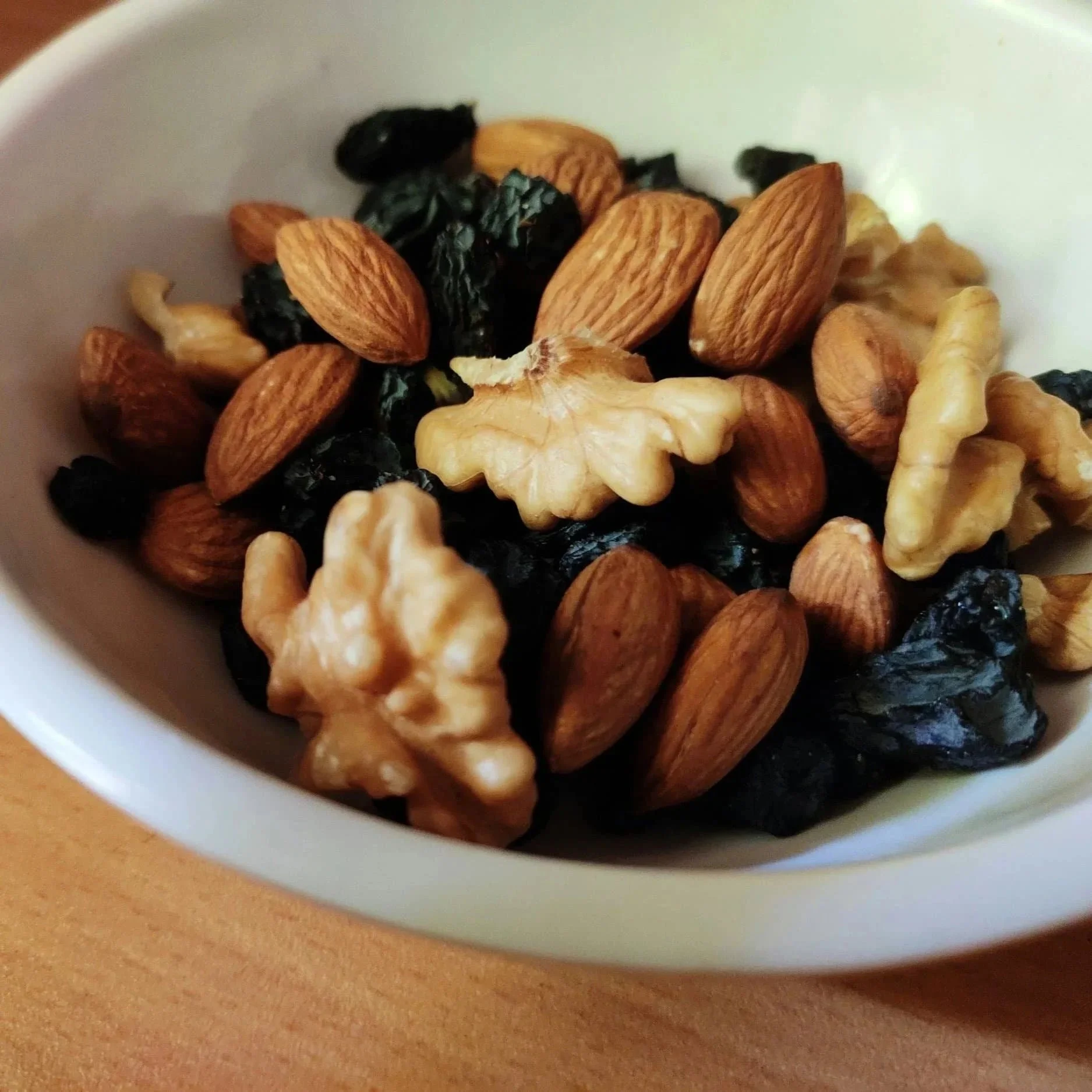 A bowl of mixed nuts - almonds, walnuts, and dried fruit