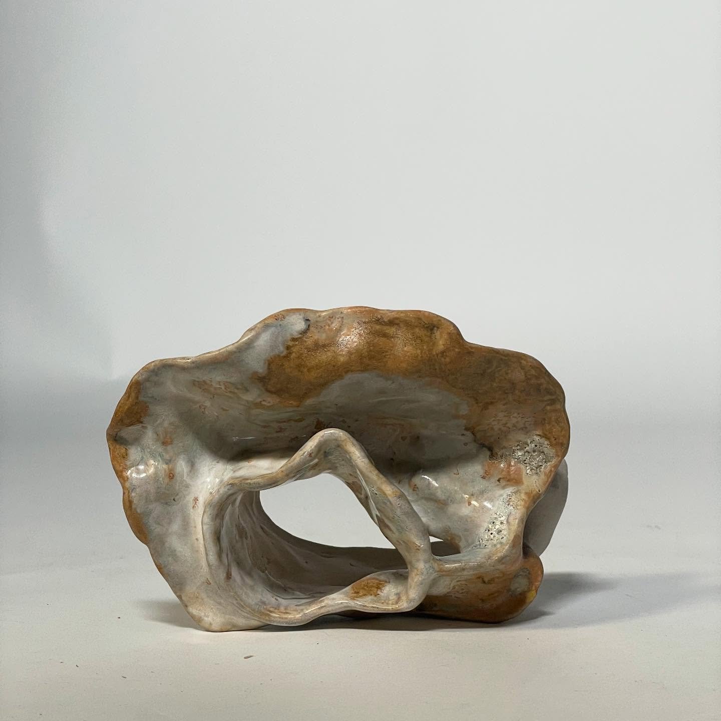 Hollow Whisper

Stoneware with glaze
2025

This vessel whispers an unfamiliar tale, her voice tentative, yet her body speaks in truths. She has endured beyond her years; the universe has etched its wisdom into every fold. Layered, weathered, luminous
