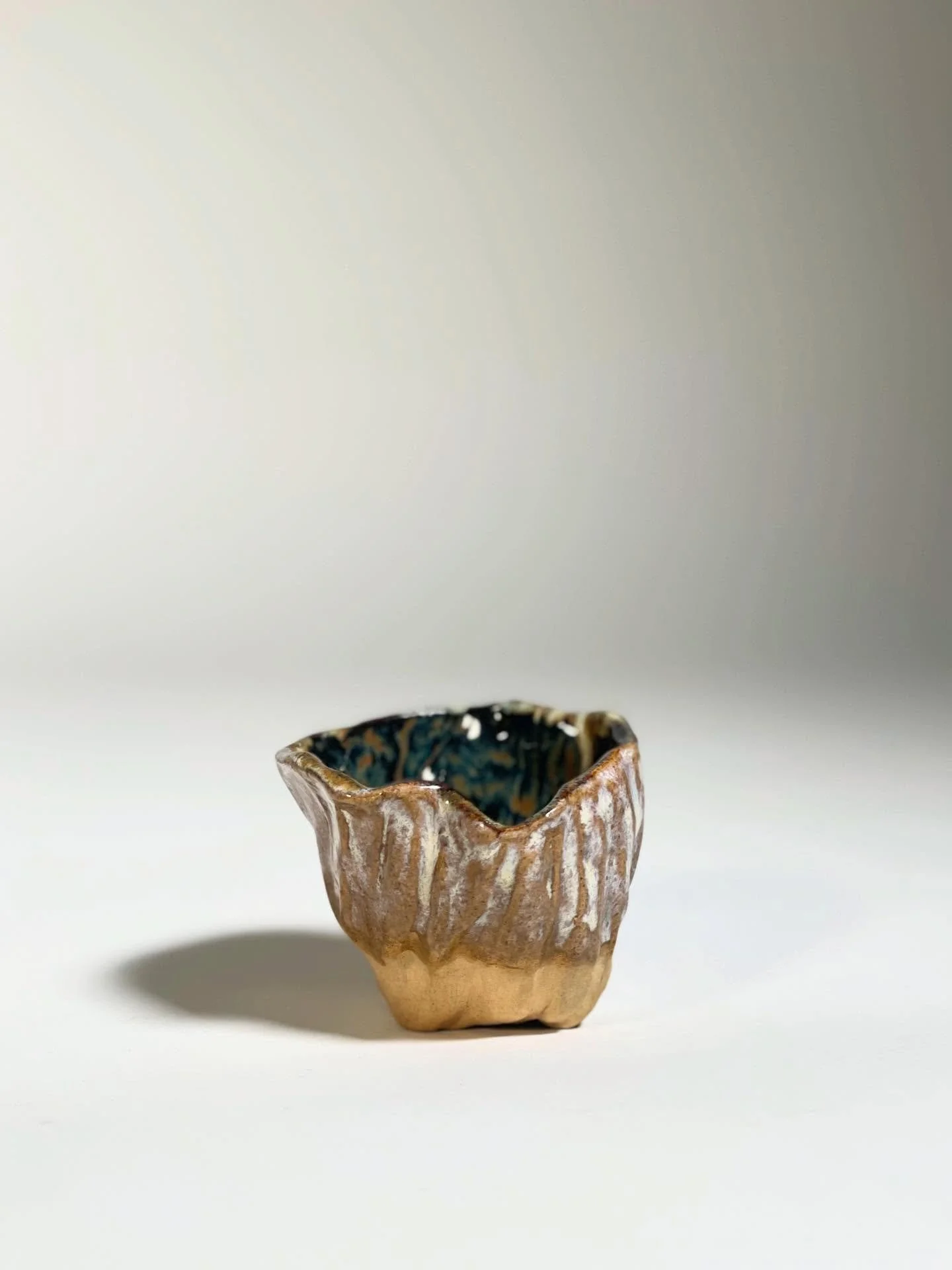 Cosmos in the Palm

This vessel carries the weight of cosmic time - as old as the universe itself, yet intimate enough to rest in a single hand. Its glaze striations echo comets and shifting skies, speaking of forces unseen yet deeply felt. Like the 